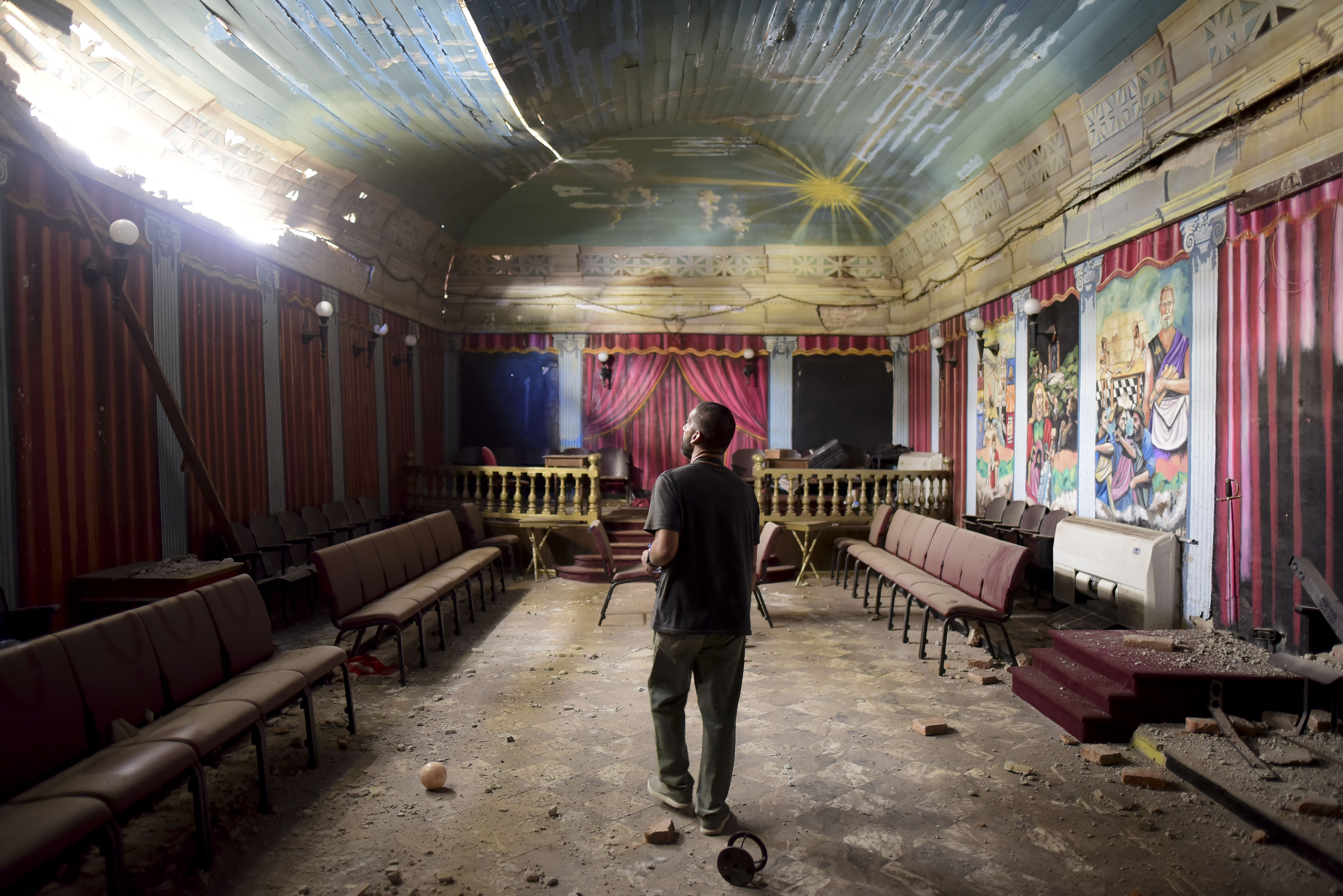 Amir Seneriz, president of the Logia Aurora Organization, inspects damages after an earthquake struck Puerto Rico before dawn, in Ponce, Puerto Rico, Tuesday, Jan. 7, 2020. (AP Photo/Carlos Giusti)