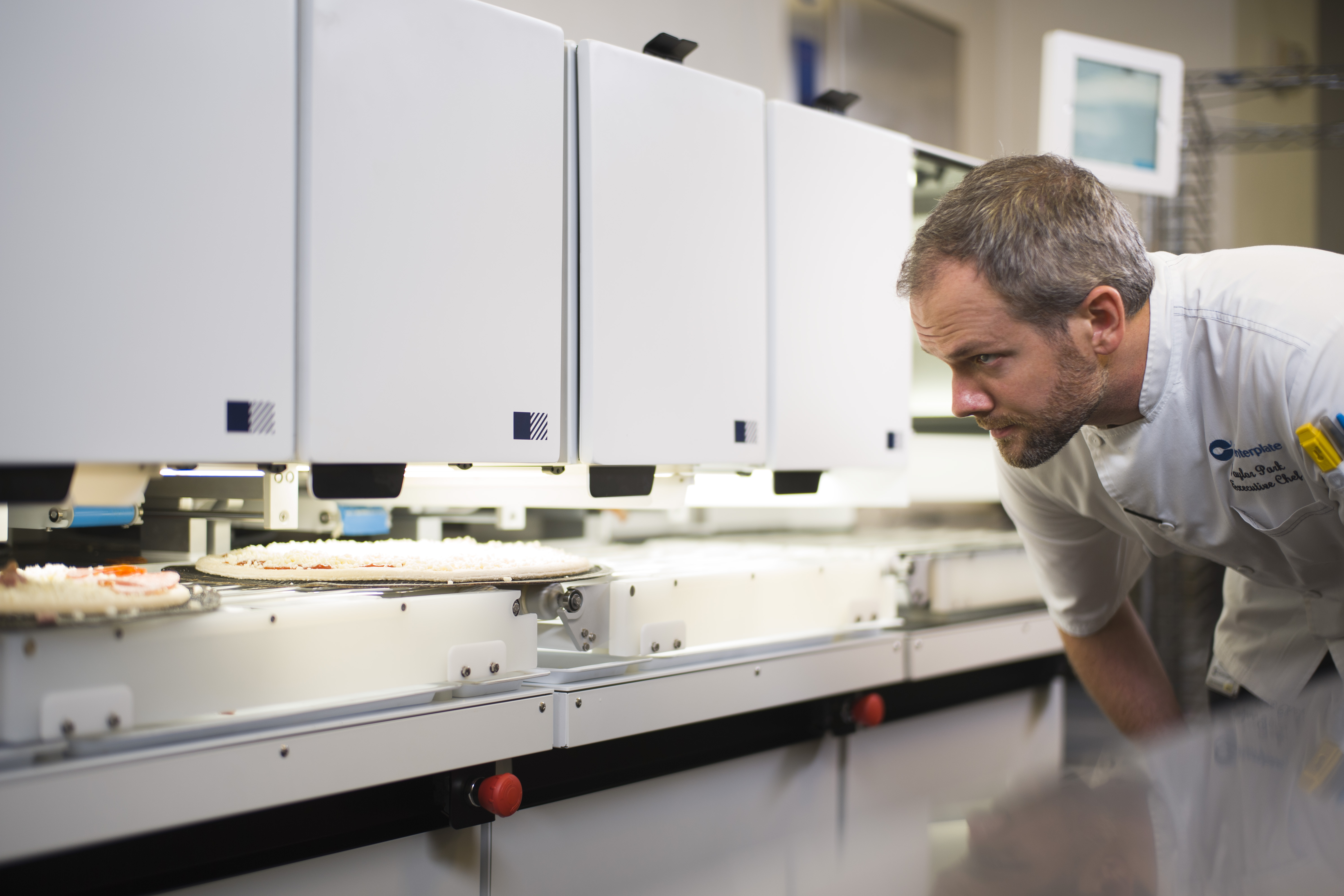 The pizza robot looks like a mini assembly line as the robot plops sauce, cheese and toppings down on the crust. (Photo: Courtesy of Picnic)