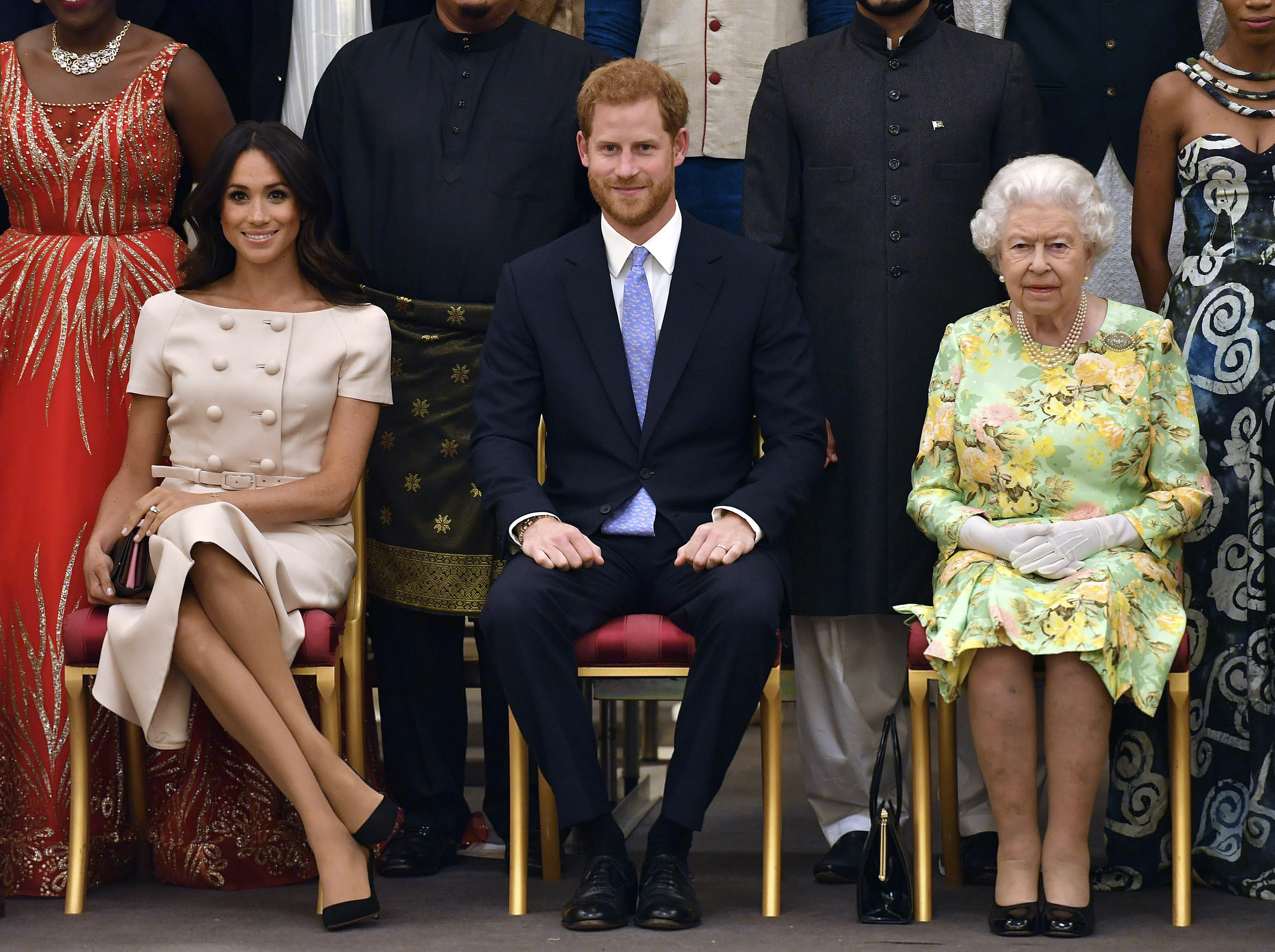 FILE - In this Tuesday, June 26, 2018 file photo, Britain's Queen Elizabeth, Prince Harry and Meghan, Duchess of Sussex pose for a group photo at the Queen's Young Leaders Awards Ceremony at Buckingham Palace in London. As part of a surprise announcement distancing themselves from the British royal family, Prince Harry and his wife Meghan declared they will “work to become financially independent” _ a move that has not been clearly spelled out and could be fraught with obstacles.(Photo: John Stillwell, Pool Photo via AP, File)