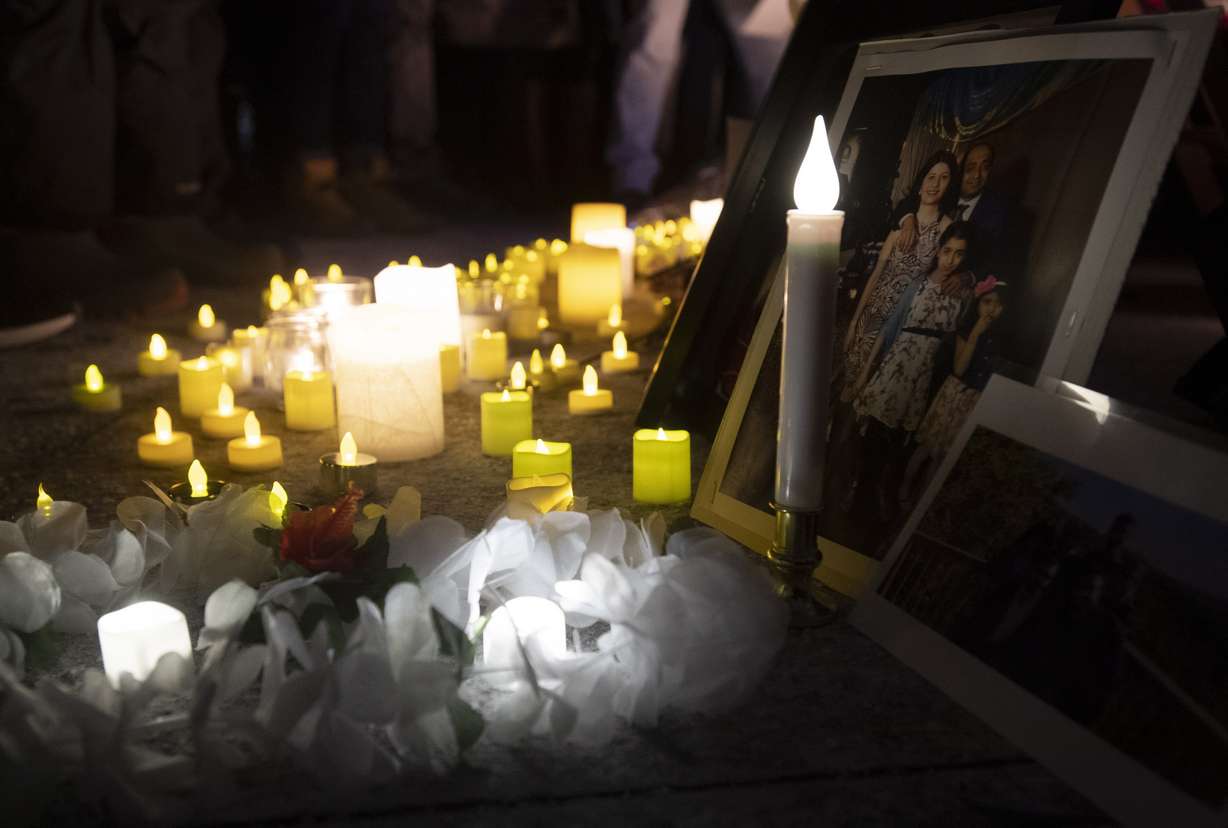 Candles sit in front of pictures of victims at a candle light vigil to remember those killed in the Ukraine International Airlines plane crash, Thursday, Jan. 9, 2020, in Ottawa, Ontario. The civilian Ukrainian jetliner crashed near Tehran late Tuesday, killing all 176 people on board. (Adrian Wyld/The Canadian Press via AP)