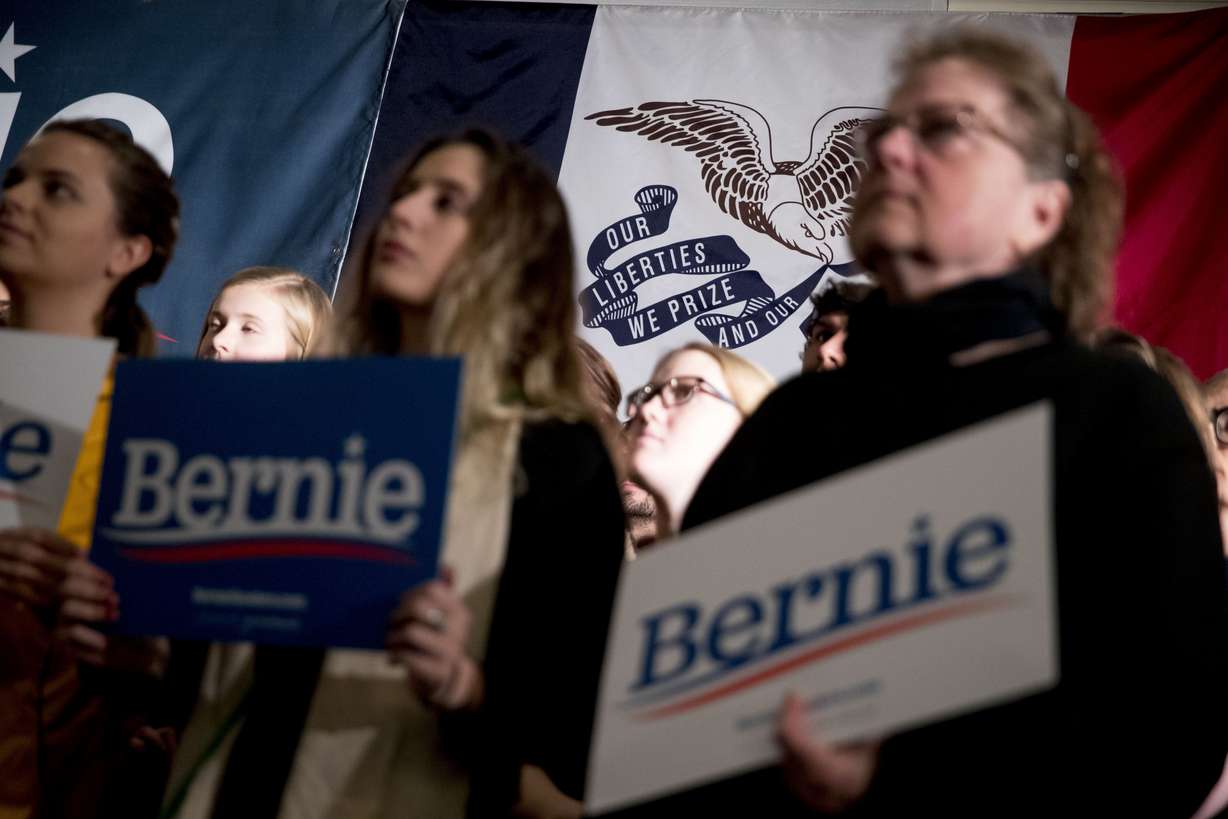 Members of the audience hold campaign posters in front of the Iowa state flag before Democratic presidential candidate Sen. Bernie Sanders, I-Vt., arrives at a climate rally with the Sunrise Movement at The Graduate Hotel, Sunday, Jan. 12, 2020. Photo: Andrew Harnik, AP Photo