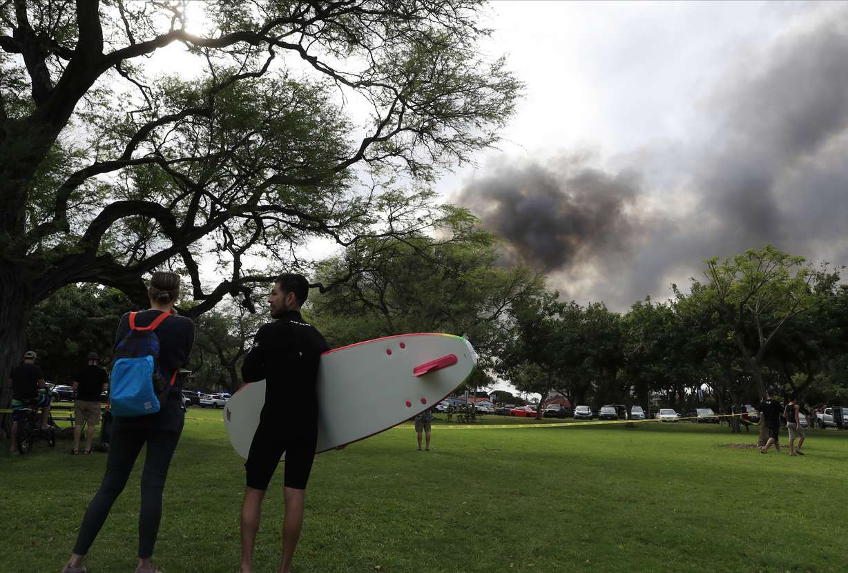 Aina Haina resident Kai Ohashi, right, and Waikiki resident Lucy Taylor observe billowing smoke from a house fire after a shooting and domestic incident at a residence on Hibiscus Road near Diamond Head on Sunday, Jan. 19, 2020, in Honolulu. Witnesses say at least two Honolulu police officers were shot and two civilians were injured. Moments after the shooting, the house was set on fire, possibly by the suspect. (Photo: Jamm Aquino/Honolulu Star-Advertiser via AP)