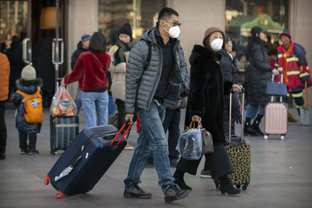 Travelers wear face masks as they walk outside of the Beijing Railway Station in Beijing, Monday, Jan. 20, 2020. China reported Monday a sharp rise in the number of people infected with a new coronavirus, including the first cases in the capital. The outbreak coincides with the country's busiest travel period, as millions board trains and planes for the Lunar New Year holidays. (Photo: Mark Schiefelbein, AP)
