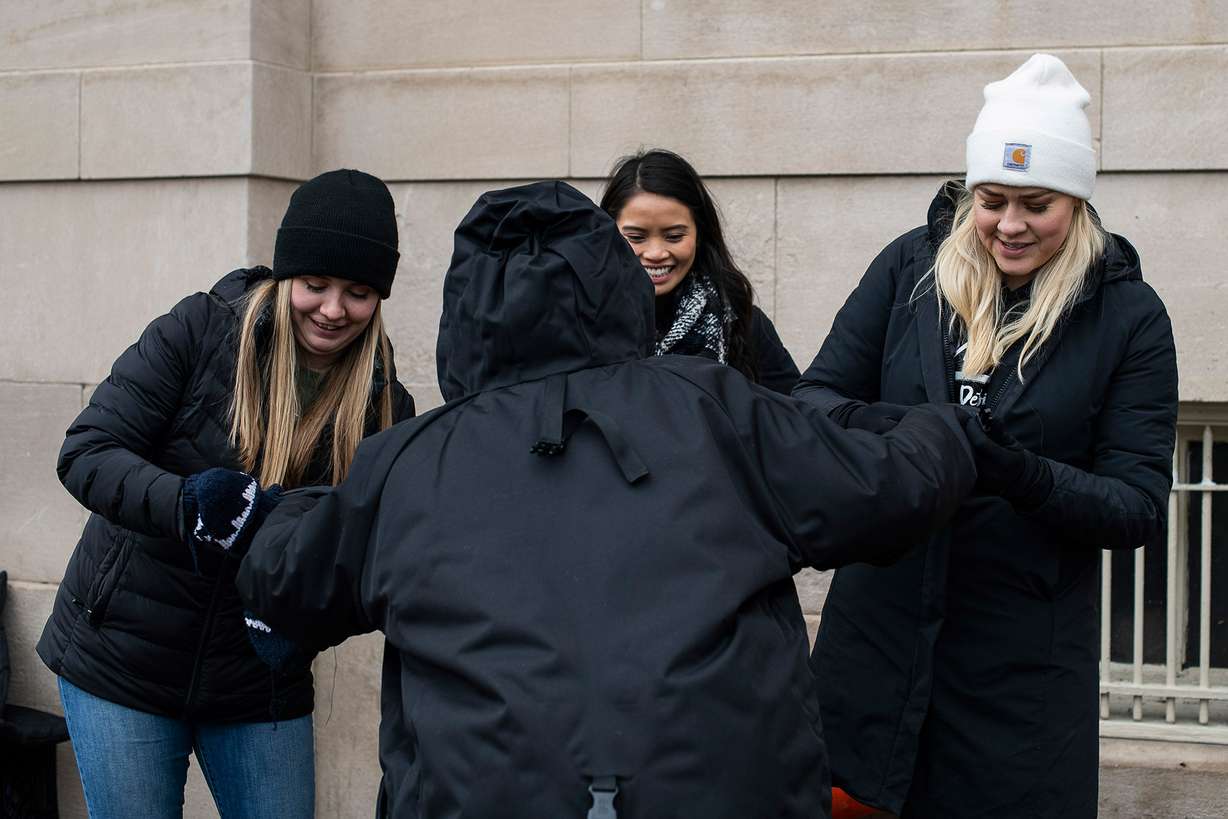 From left, Ellie Small and Mari Gener of MSU Detroit Street Care and Scott help a homeless woman with a new coat. (Photo: Brittany Greeson for CNN)