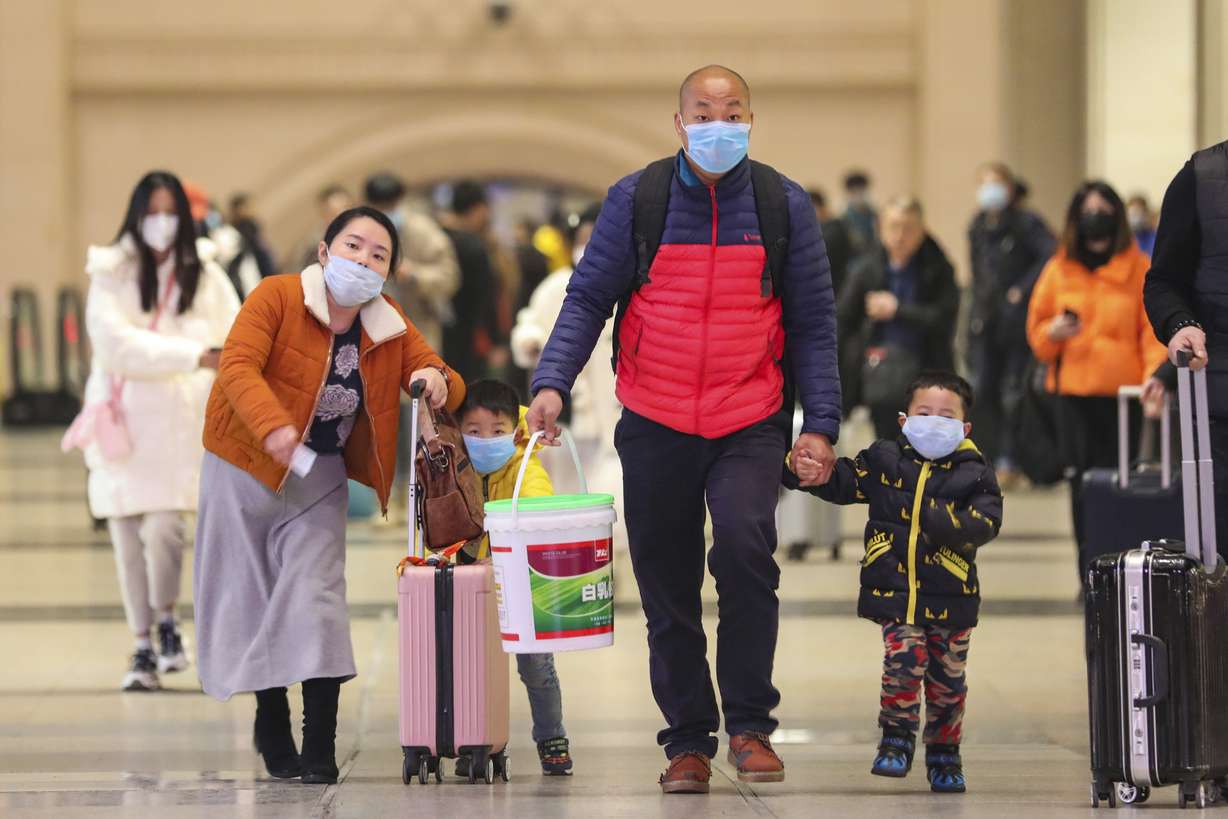 In this Tuesday, Jan. 21, 2020, photo, travelers wearing face masks walk with their luggage at Hankou Railway Station in Wuhan in southern China's Hubei province. The U.S. on Tuesday reported its first case of a new and potentially deadly virus circulating in China, saying a Washington state resident who returned last week from the outbreak's epicenter was hospitalized near Seattle. (Photo: Chinatopix via AP)