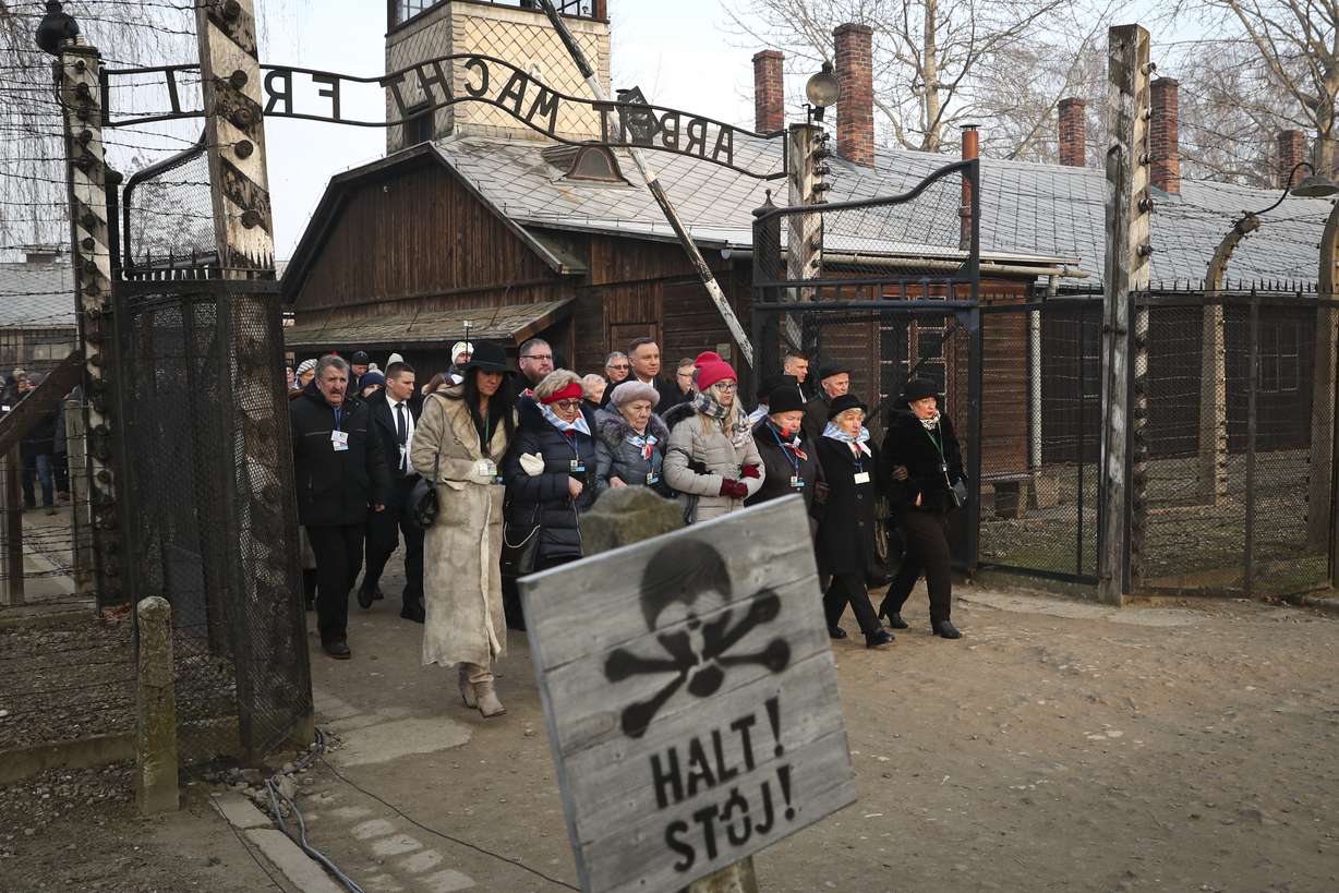 Poland's President Andrzej Duda walks along with survivors through the gates of the Auschwitz Nazi concentration camp to attend the 75th anniversary of its liberation in Oswiecim, Poland, Monday, Jan. 27, 2020. (AP Photo/Czarek Sokolowski)