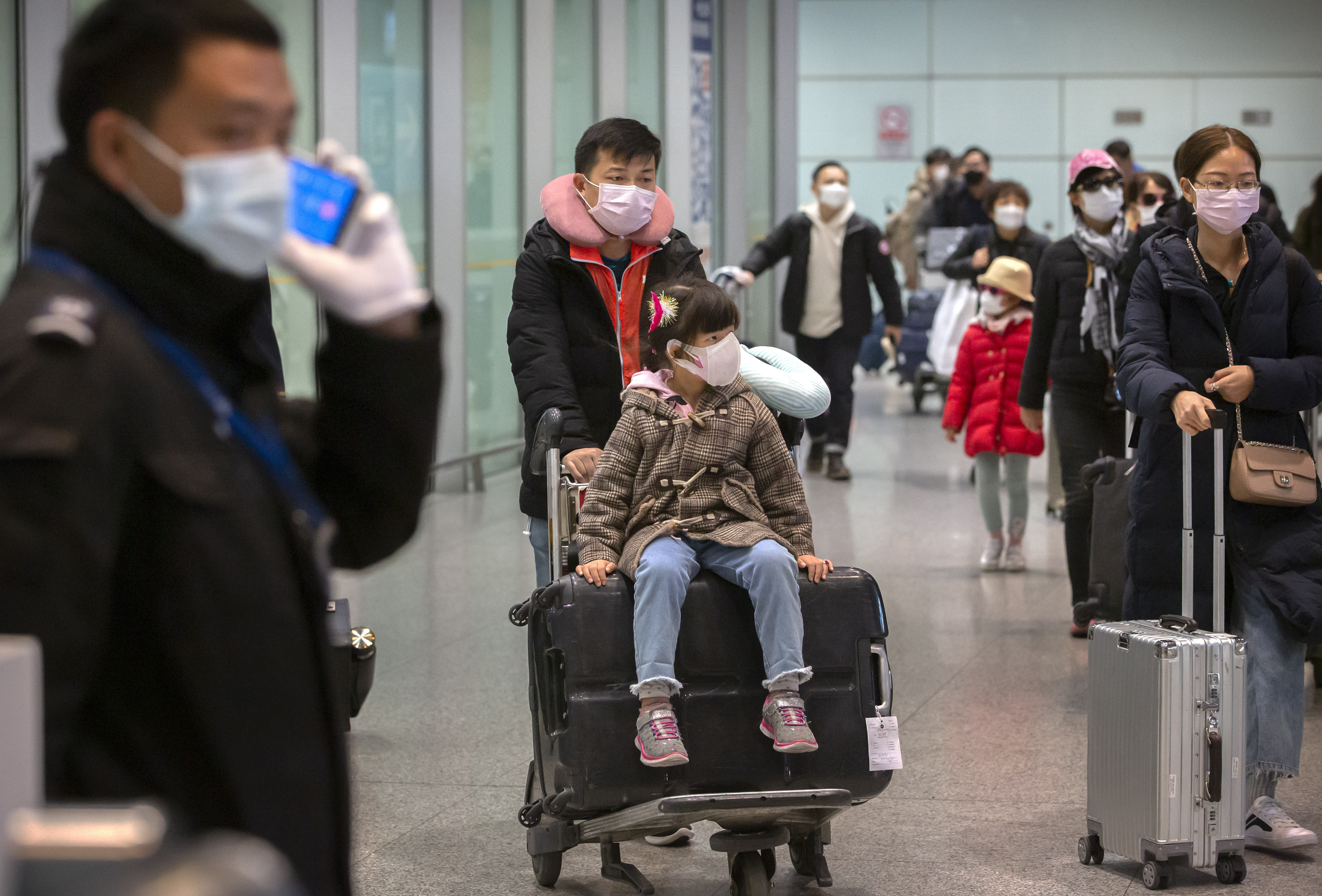 Travelers wearing face masks enter the international arrivals area at Beijing Capital International Airport in Beijing, Thursday, Jan. 30, 2020. China counted 170 deaths from a new virus Thursday and more countries reported infections, including some spread locally, as foreign evacuees from China's worst-hit region returned home to medical observation and even isolation. (Mark Schiefelbein, AP Photo)
