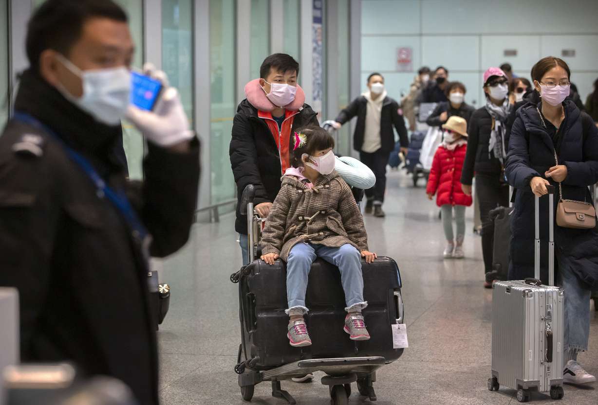 Travelers wearing face masks enter the international arrivals area at Beijing Capital International Airport in Beijing, Thursday, Jan. 30, 2020. China counted 170 deaths from a new virus Thursday and more countries reported infections, including some spread locally, as foreign evacuees from China's worst-hit region returned home to medical observation and even isolation. (Mark Schiefelbein, AP Photo)