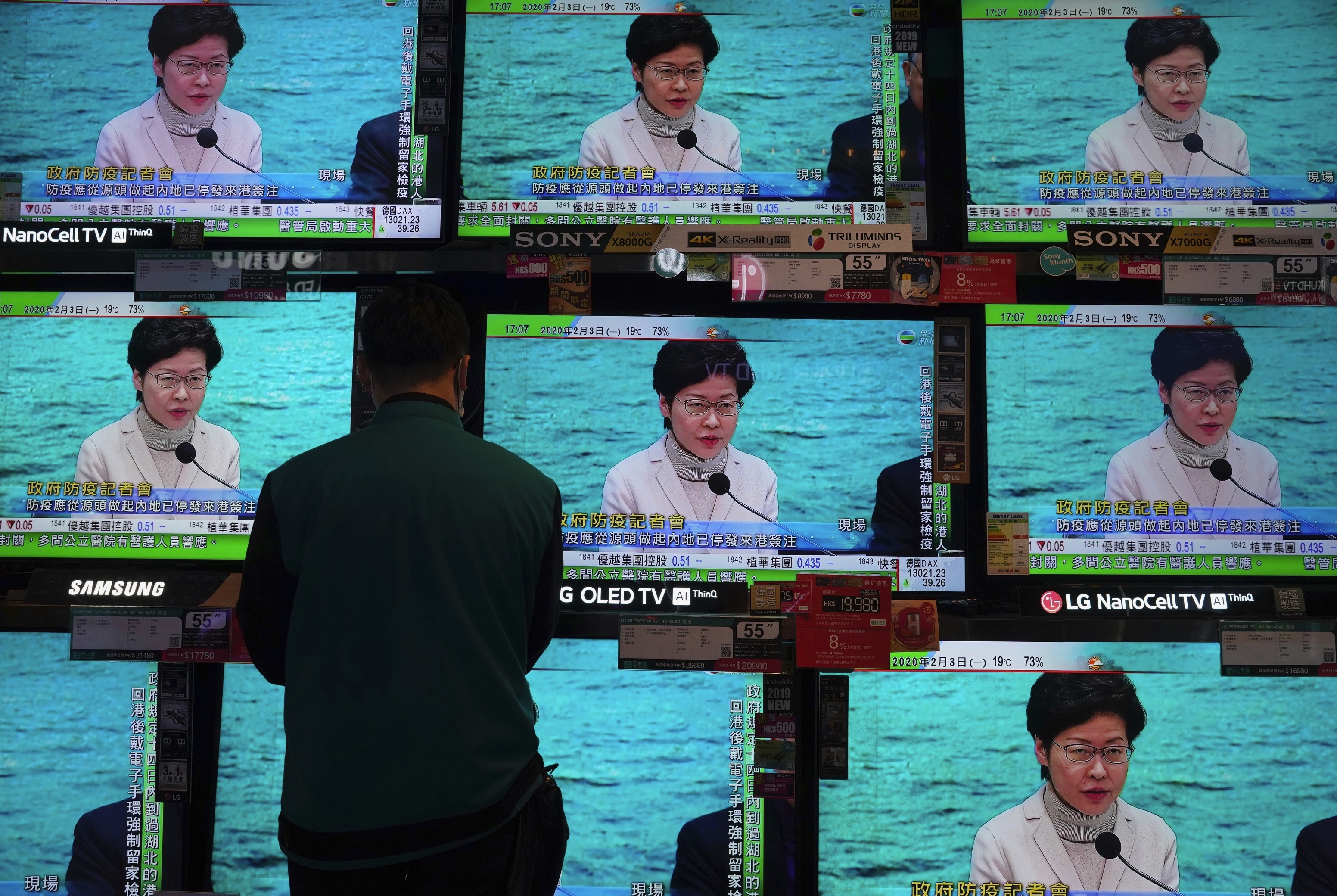 A man wears protective face masks stands in front of TV screens broadcasting Hong Kong Chief Executive Carrie Lam delivering a speech in Hong Kong, Monday, Feb. 3, 2020. Photo: Vincent Yu, AP Photo