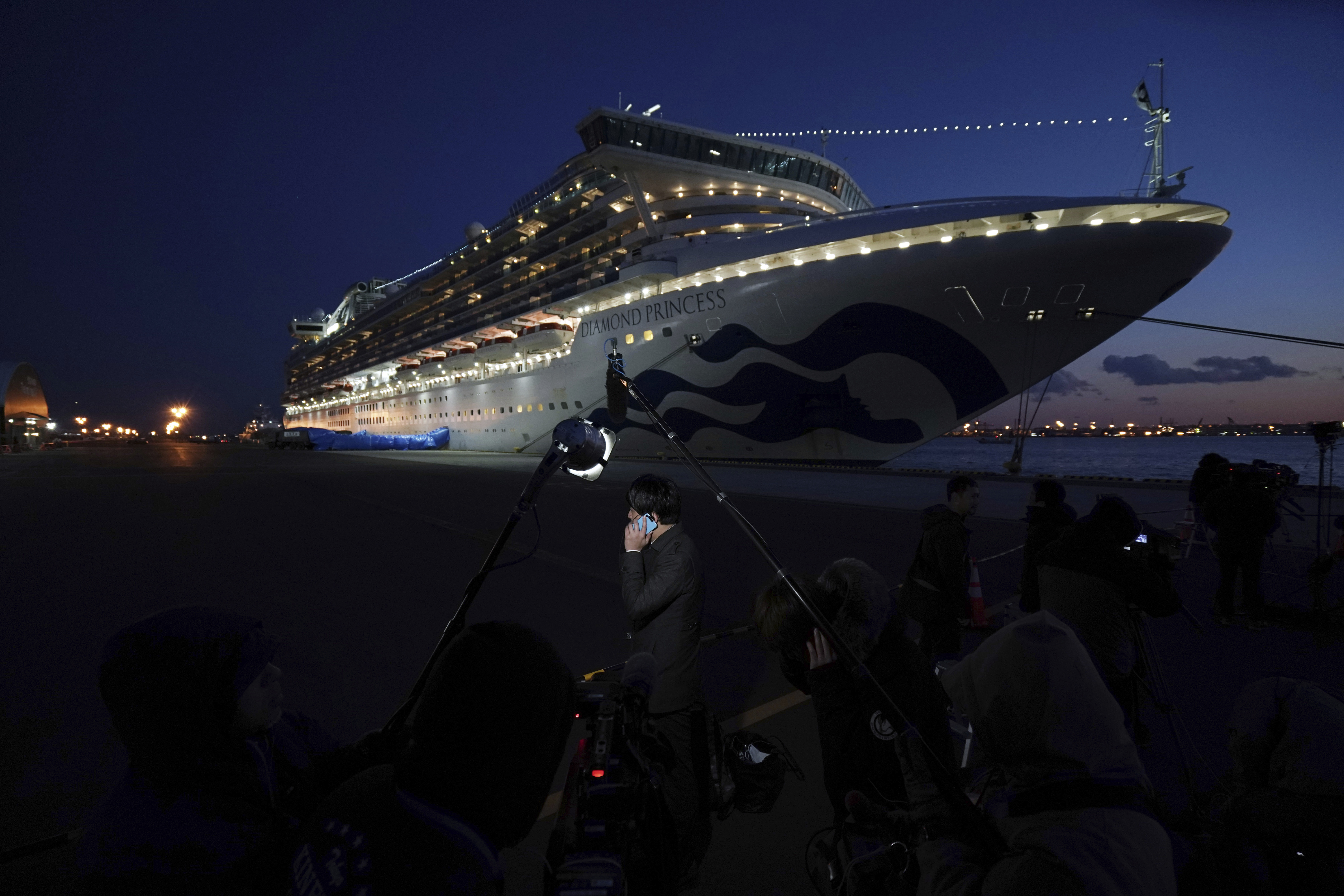 Journalists work near the quarantined Diamond Princess cruise ship sitting at the Yokohama Port Monday, Feb. 10, 2020, Yokohama, Japan. The operator of the ship said Monday that an additional 66 cases were found aboard. That is in addition to 70 reported earlier. (Eugene Hoshiko, AP Photo)