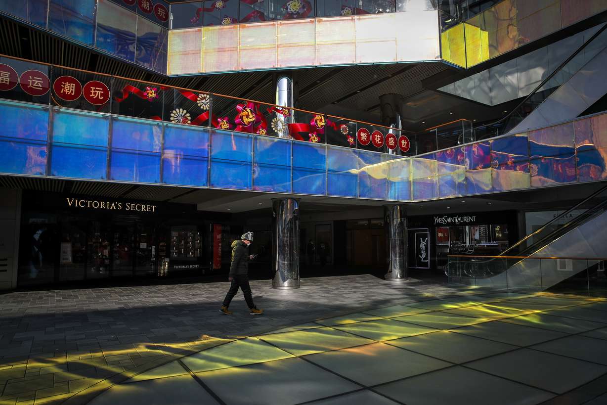 A masked man walks by a quiet shopping mall during a lunch hours in Beijing, Monday, Feb. 10, 2020. China reported a rise in new virus cases on Monday, possibly denting optimism that its disease control measures like isolating major cities might be working, while Japan reported dozens of new cases aboard a quarantined cruise ship. (Andy Wong, AP Photo)