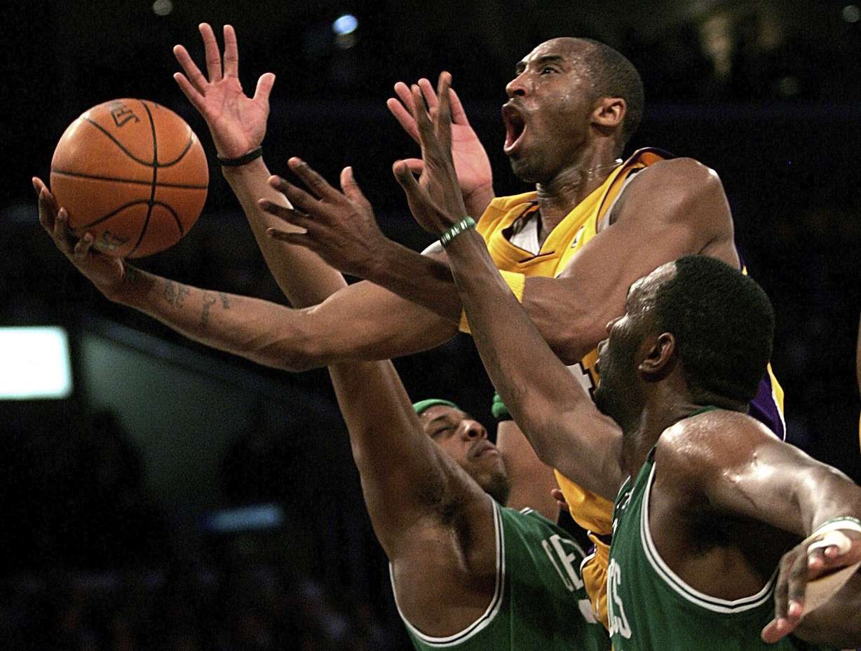 In this Feb. 23, 2007, file photo, Los Angeles Lakers' Kobe Bryant, top, goes up for a shot between Boston Celtics' Paul Pierce, left, and Al Jefferson during the first half of an NBA basketball game in Los Angeles. Bryant was one of eight finalists announced Friday, Feb. 14, 2020, as candidates for enshrinement into the Basketball Hall of Fame later this year, a decision that came as absolutely no surprise in his first year of eligibility. (AP Photo: Branimir Kvartuc, File)