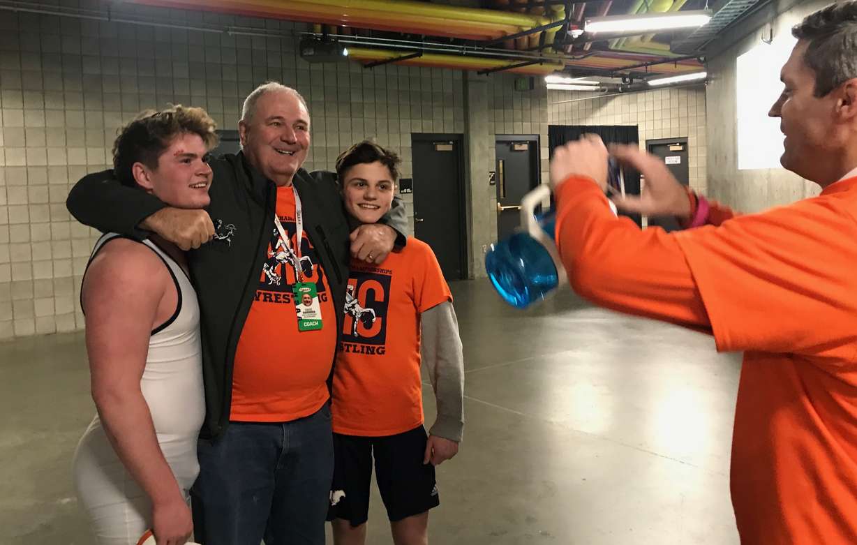 Longtime Mountain Crest wrestling coach Davie Swensen poses for a photo with brothers Hunter Schroeder, left, and Luke Schroeder, just as he did 30 years prior with their father Greg and uncle Kirk after winning a pair of state titles. (Photo: Sean Walker, KSL.com)