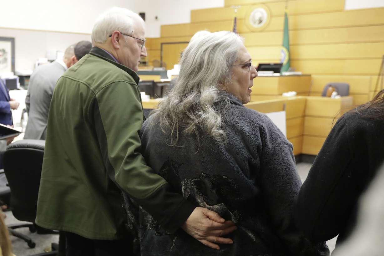 Chuck Cox, left, and his wife, Judy Cox, right, stand Tuesday, Feb. 18, 2020, during a break in a session of Pierce County Superior Court in Tacoma, Wash., on the first day of a civil lawsuit over the murder of the Cox's young grandsons. (Ted S. Warren, AP Photo)
