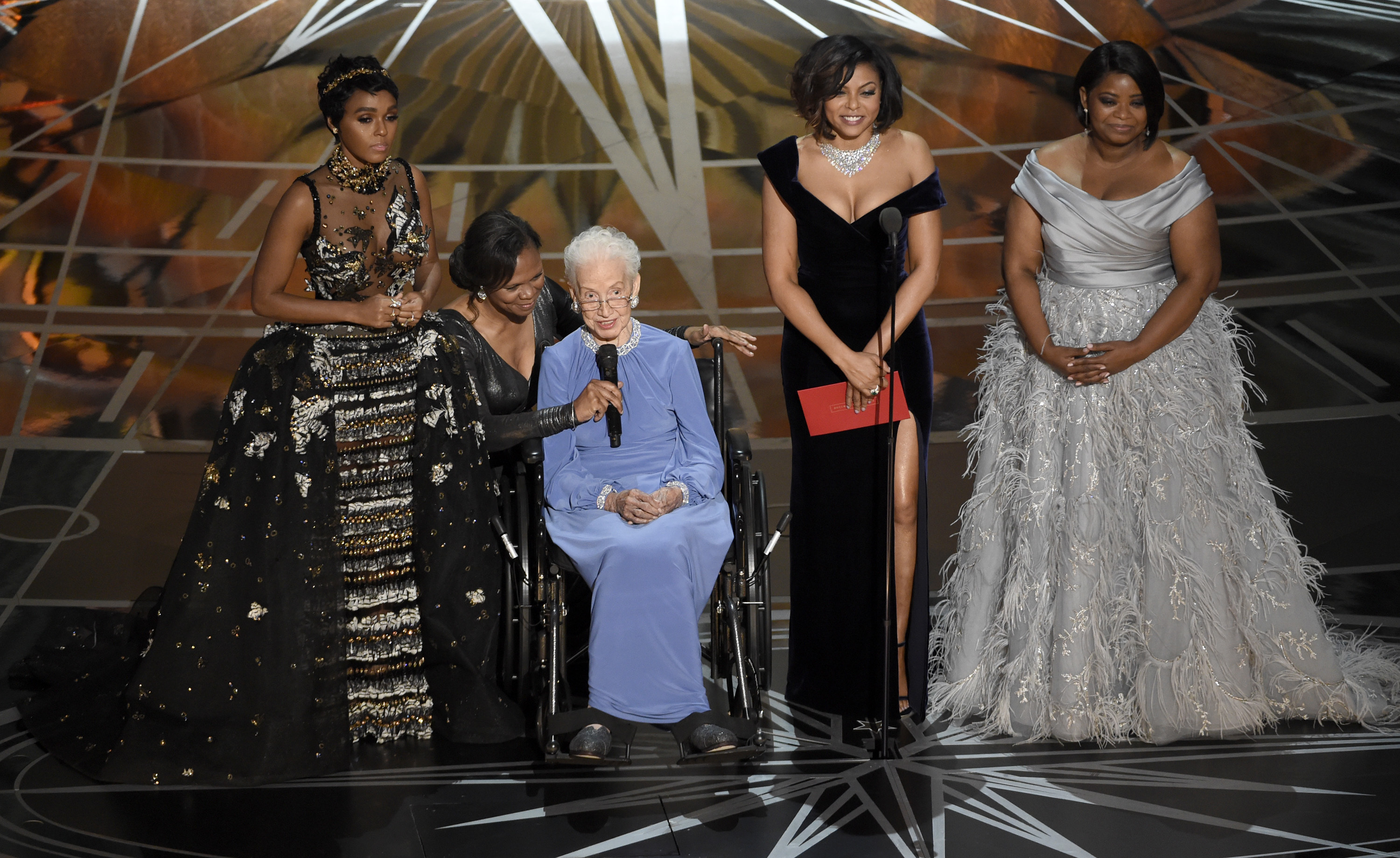 FILE - In this Feb. 26, 2017, file photo Janelle Monae, left, Taraji P. Henson, second right and Octavia Spencer, right, introduce Katherine Johnson, seated, the inspiration for "Hidden Figures," as they present the award for best documentary feature at the Oscars at the Dolby Theatre in Los Angeles. Johnson, a mathematician on early space missions who was portrayed in film "Hidden Figures," about pioneering black female aerospace workers, died Monday, Feb. 24, 2020. (Photo by Chris Pizzello/Invision/AP, File)