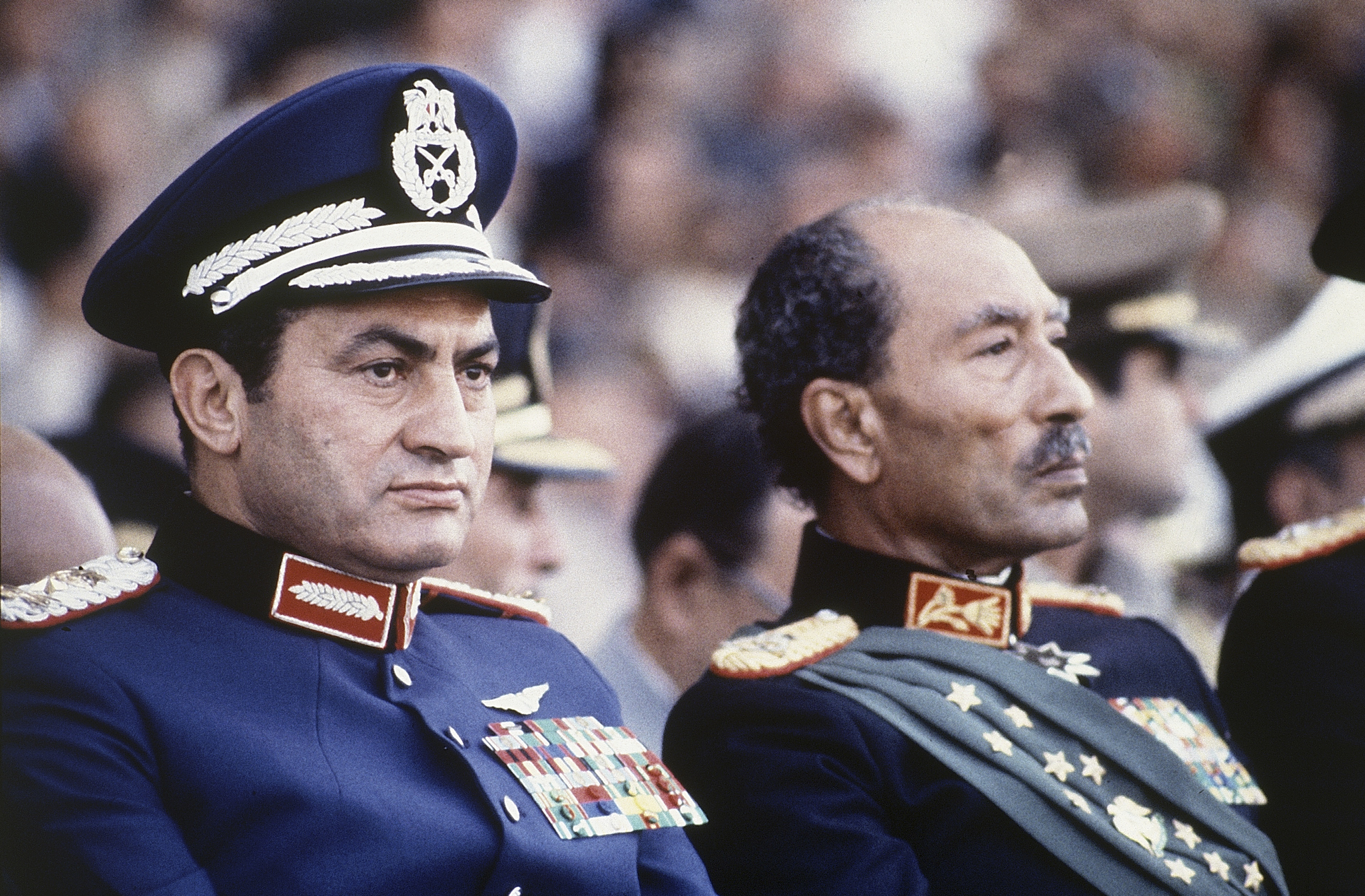 In this Oct. 6, 1981 file photo, Egyptian President Anwar Sadat, right, and Vice President Hosni Mubarak sit on the reviewing stand during a military parade just before soldiers opened fire from a truck during the parade at the reviewing stand, killing Sadat and injuring Mubarak. (AP Photo/Bill Foley, File)