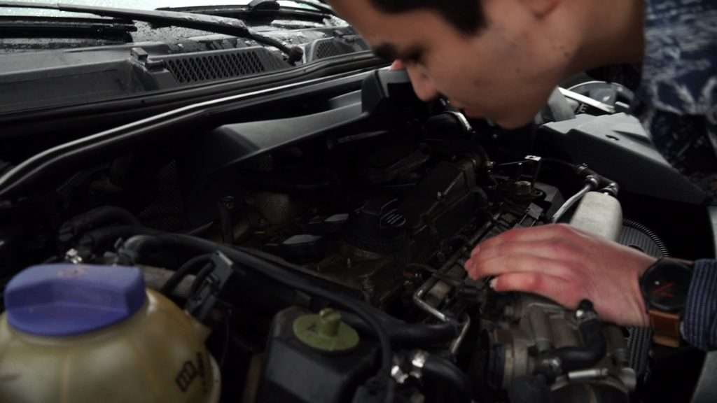 Antonio Lopez opens up a cover in his car’s engine compartment to get a look at the failed timing belt. Photo: KSL TV