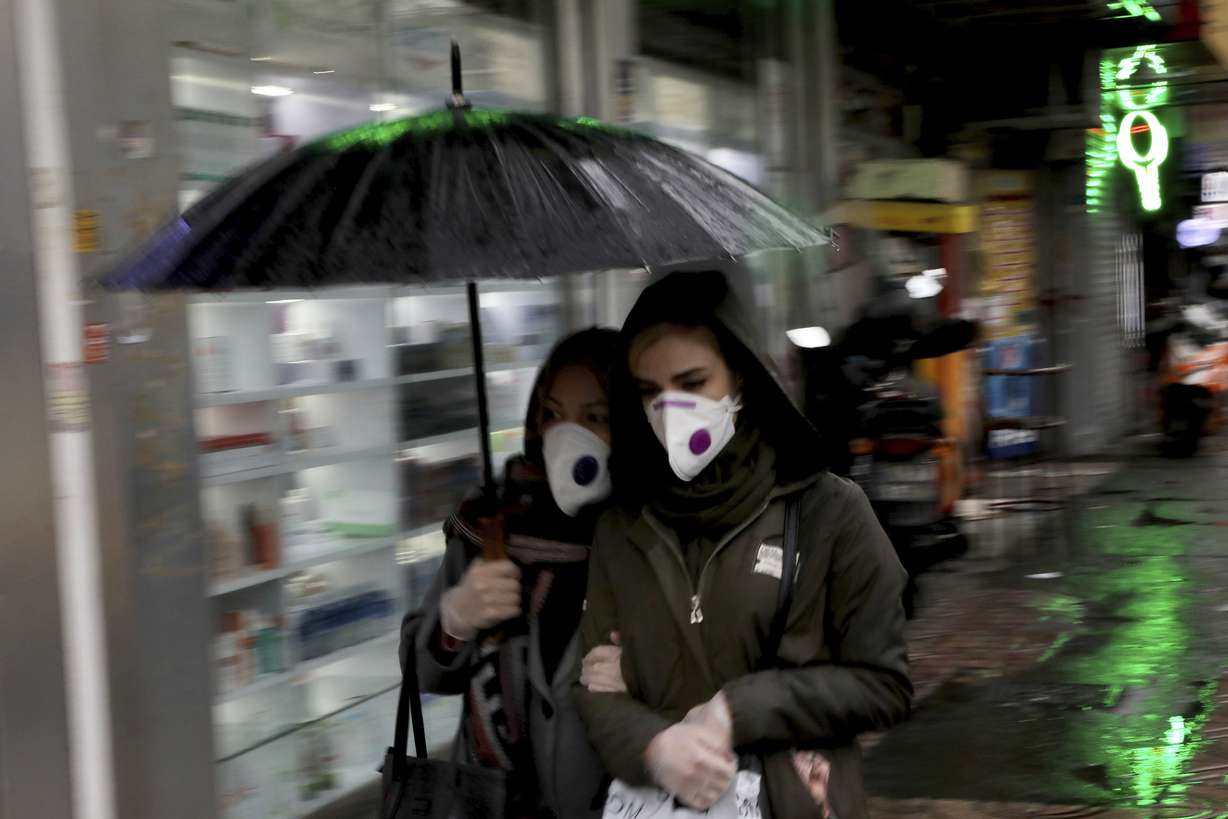 Pedestrians wear masks and gloves to help guard against the Coronavirus in downtown Tehran, Iran, Tuesday, Feb. 25, 2020. (Ebrahim Noroozi, AP Photo)