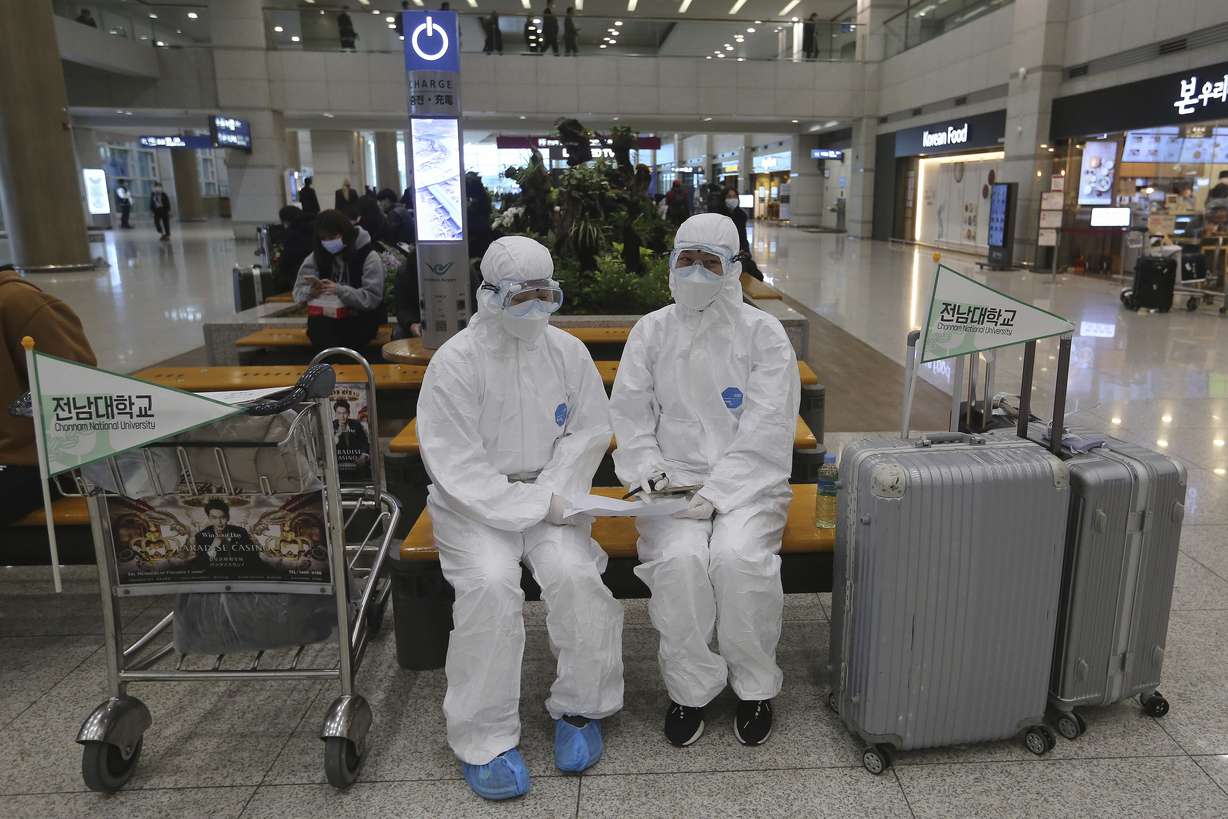 Chonnam National University staff wearing protective attire are on standby for special transportation for Chinese students studying at their university, at Incheon International Airport in Incheon, South Korea, Tuesday, Feb. 25, 2020. (Ahn Young-joon, AP Photo)