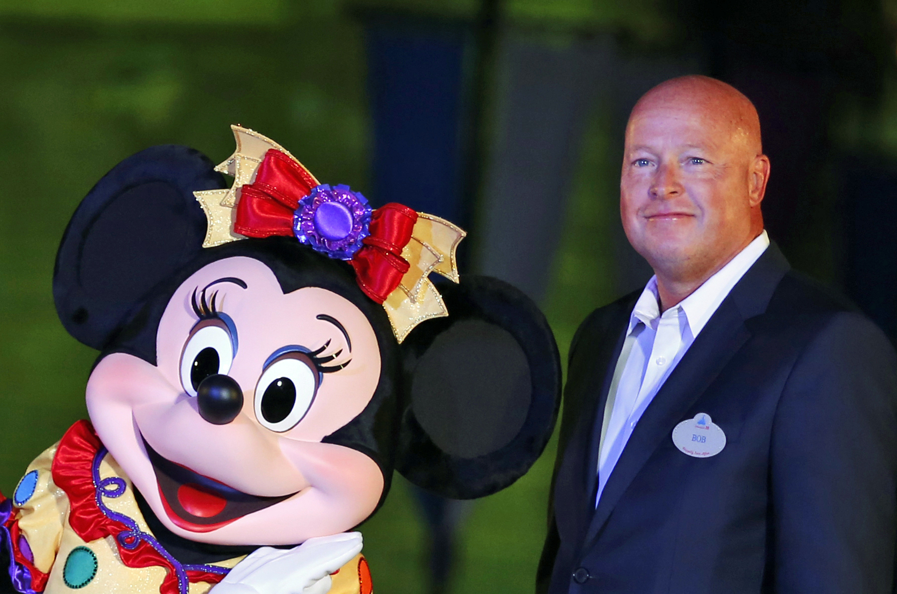 FILE - In this Sept. 11, 2015, file photo, Chairman of Walt Disney Parks and Resorts Bob Chapek poses with Minnie Mouse during a ceremony at the Hong Kong Disneyland, as they celebrate the Hong Kong Disneyland's 10th anniversary. The Walt Disney Co. has named Bob Chapek CEO, replacing Bob Iger, effective immediately, the company announced Tuesday, Feb. 25, 2020. (Kin Cheung, AP Photo, File)