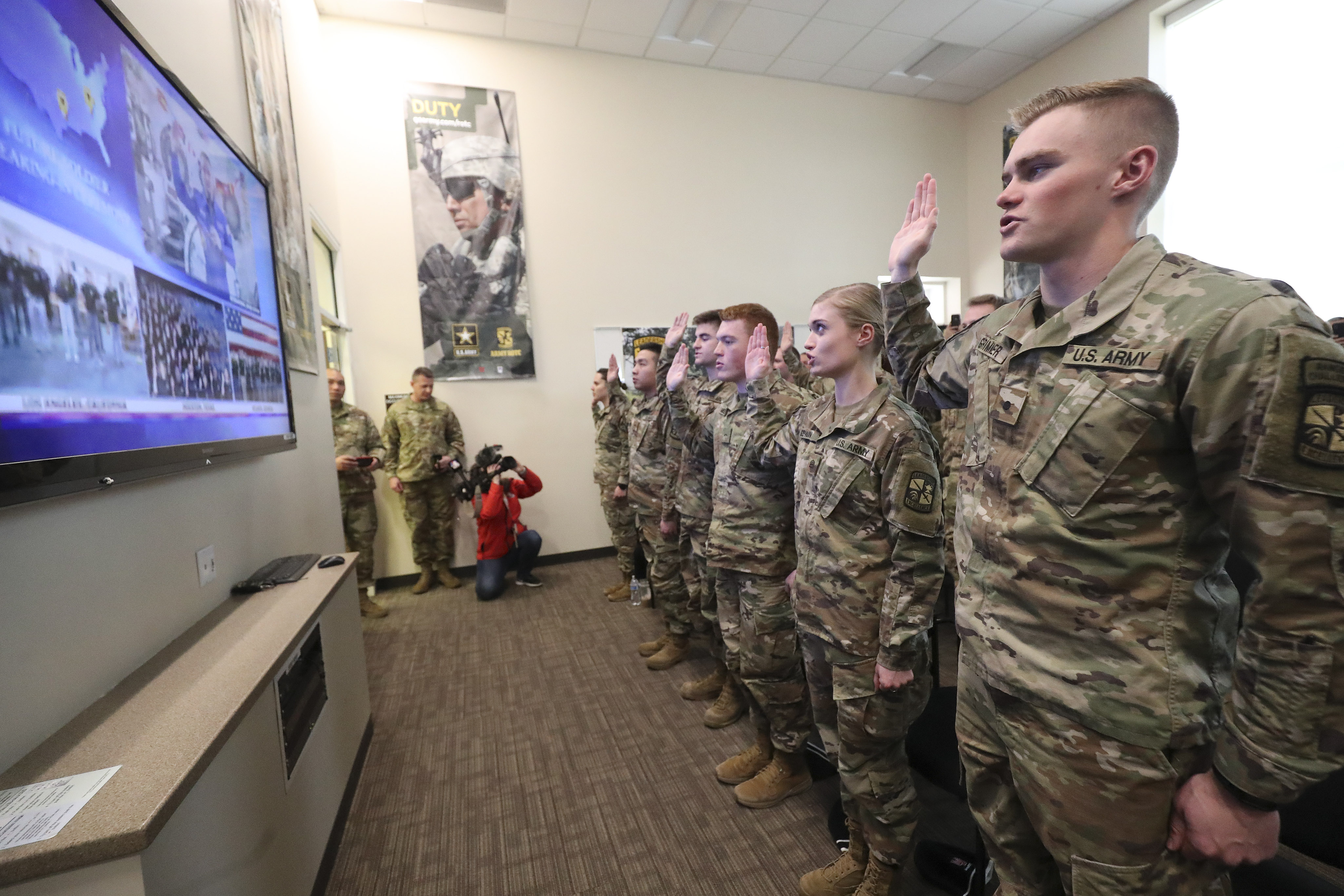 Andrew Grimmer, right, and others raise their hands during a U.S. Army oath of enlistment ceremony at the University of Utah in Salt Lake City on Wednesday, Feb. 26, 2020. The oath was administered by U.S. Army Col. and NASA astronaut Andrew Morgan from the International Space Station. More than 850 future soldiers participated in the ceremony, the product of a partnership between NASA and U.S. Army Recruiting Command, at more than 130 locations across the country. (Jeffrey D Allred, KSL)