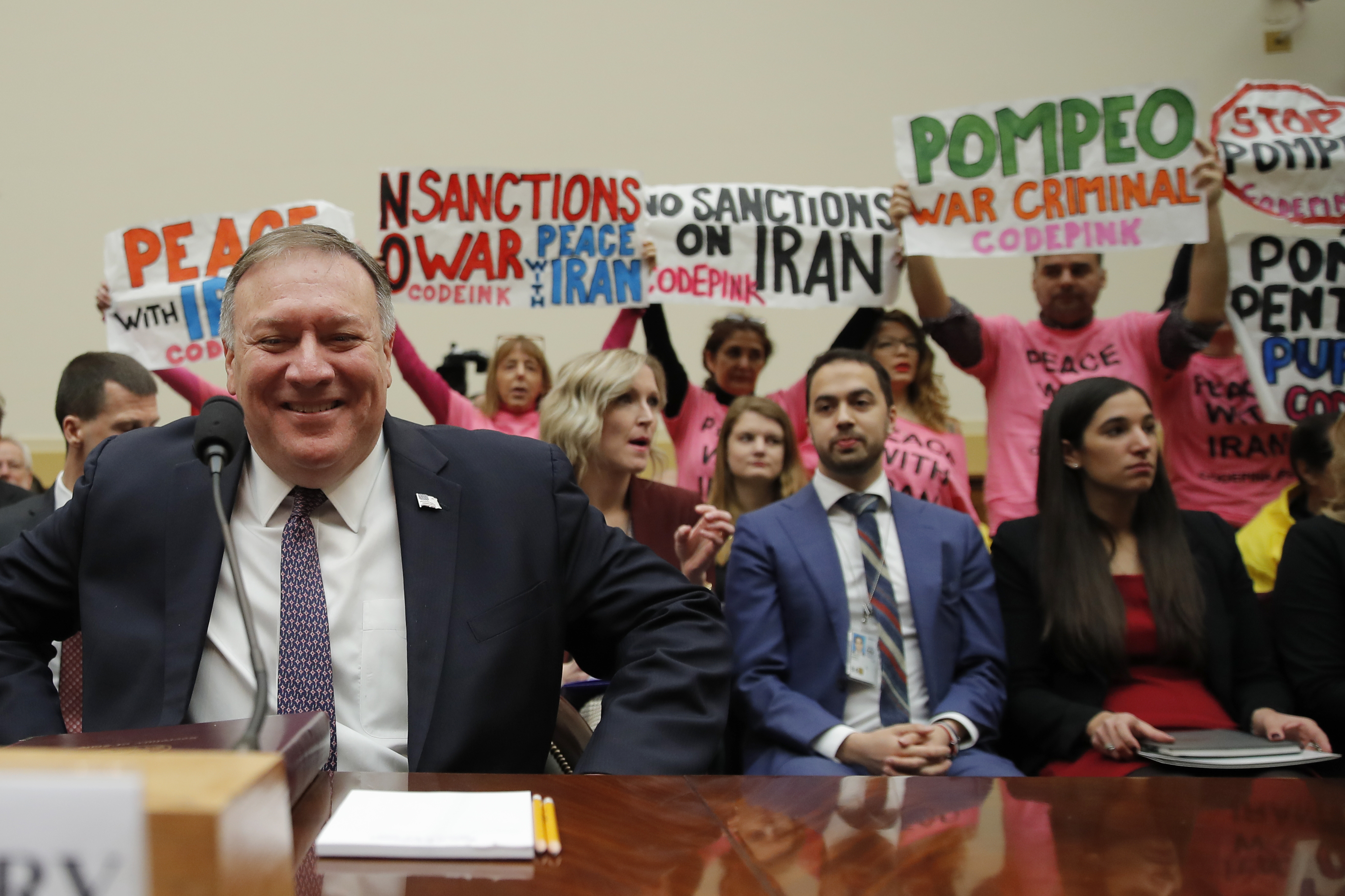 Protesters hold up signs as Secretary of State Mike Pompeo arrives to testify at a House Foreign Affairs Committee hearing on Capitol Hill in Washington, Friday, Feb. 28, 2020, about the Trump administration's policies on Iran, Iraq and the use of force. (Carolyn Kaster, AP Photo)