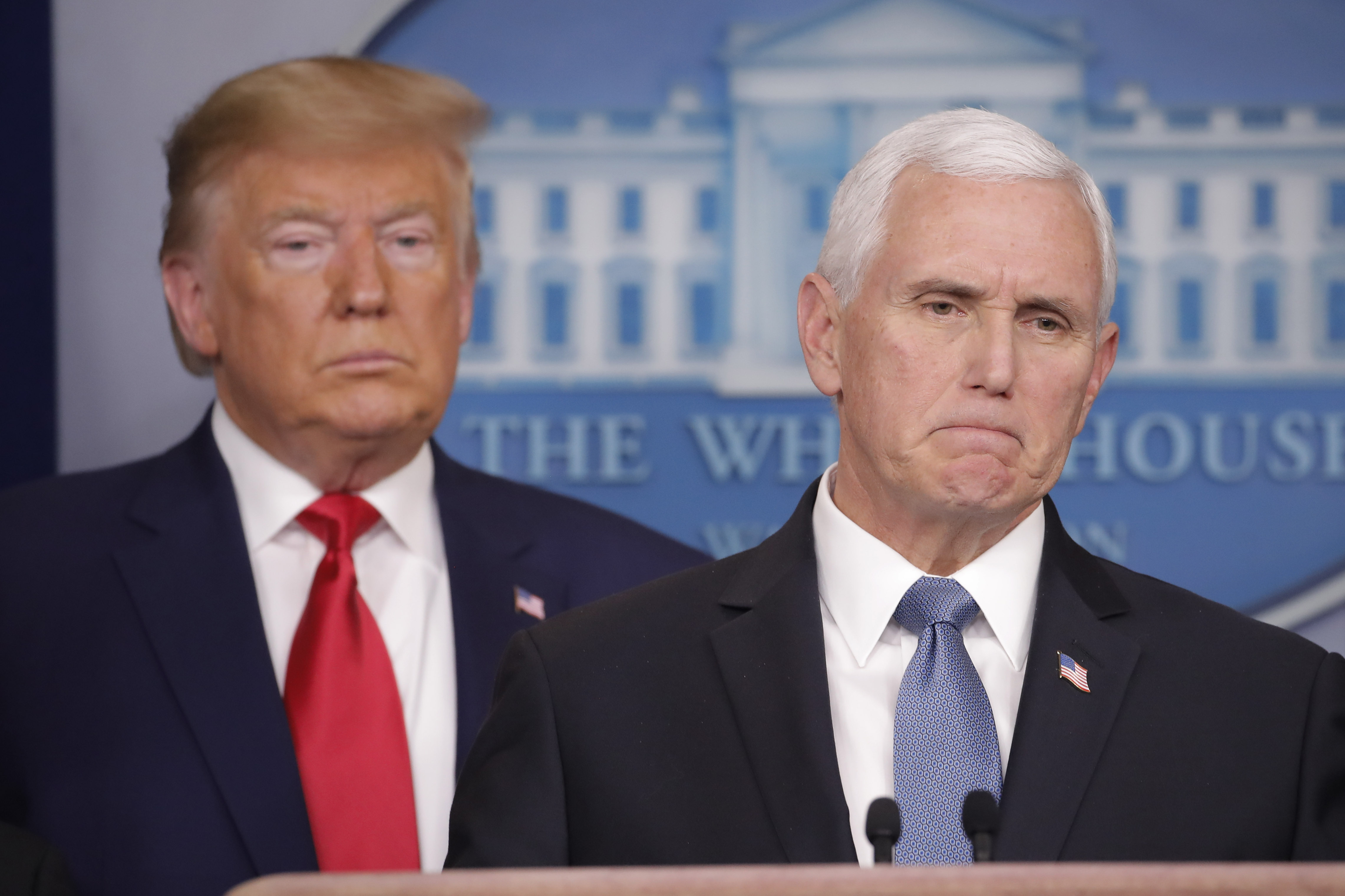 President Donald Trump, left, listens to Vice President Mike Pence, right, as he pauses while speaking to members of the media to address the nation about the coronavirus threat in the Brady Press Briefing room of the White House in Washington, Saturday, Feb. 29, 2020. (Carolyn Kaster, AP Photo)