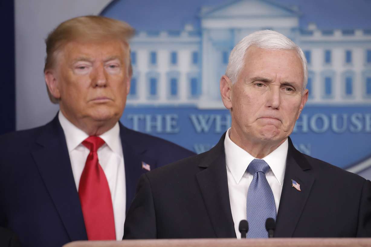 President Donald Trump, left, listens to Vice President Mike Pence, right, as he pauses while speaking to members of the media to address the nation about the coronavirus threat in the Brady Press Briefing room of the White House in Washington, Saturday, Feb. 29, 2020. (Carolyn Kaster, AP Photo)