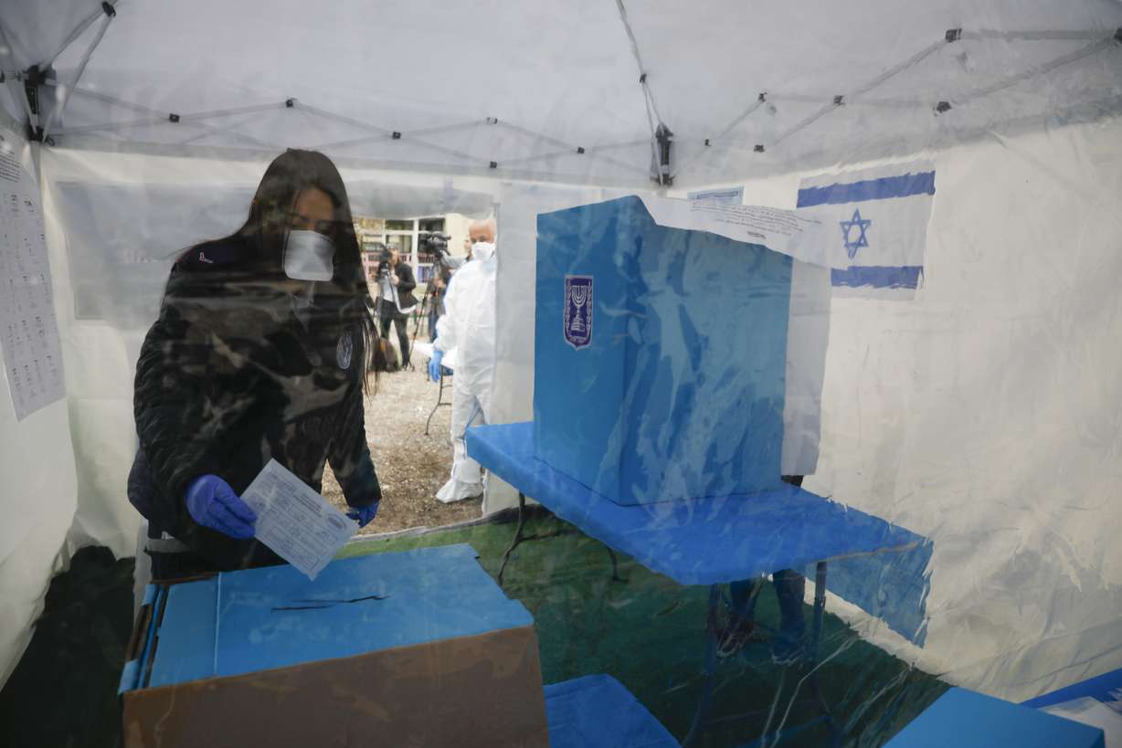 A woman quarantined for Corona virus votes in a specially set up tent in Tel Aviv, Israel, Monday, March 2, 2020. (Ariel Schalit, AP Photo)