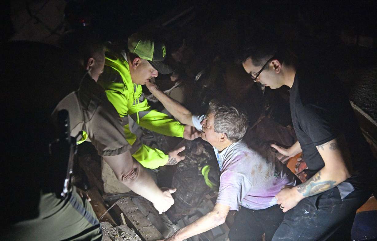 Bill Wallace reaches out to rescue workers who freed him from his home that collapsed on him and his wife Shirley trapping them under rubble after a tornado hit Mt. Juliet, Tenn., on Tuesday, March 3, 2020. (Larry McCormack, The Tennessean via AP)