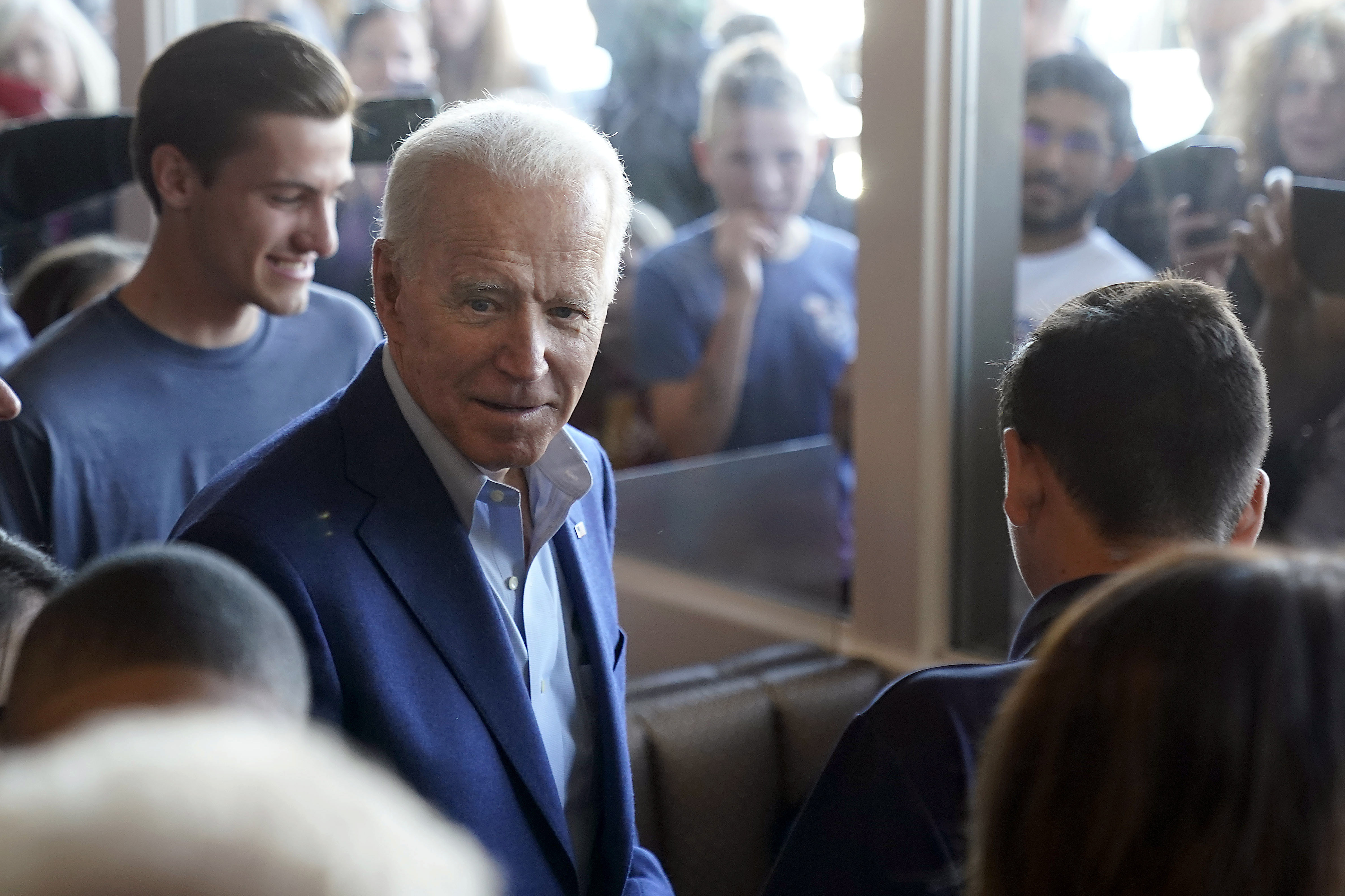 Democratic presidential candidate former Vice President Joe Biden talks with customers people watch through the window's at the Buttercup Diner during a campaign stop in Oakland, Calif., Tuesday, March 3, 2020. (Tony Avelar, AP Photo)
