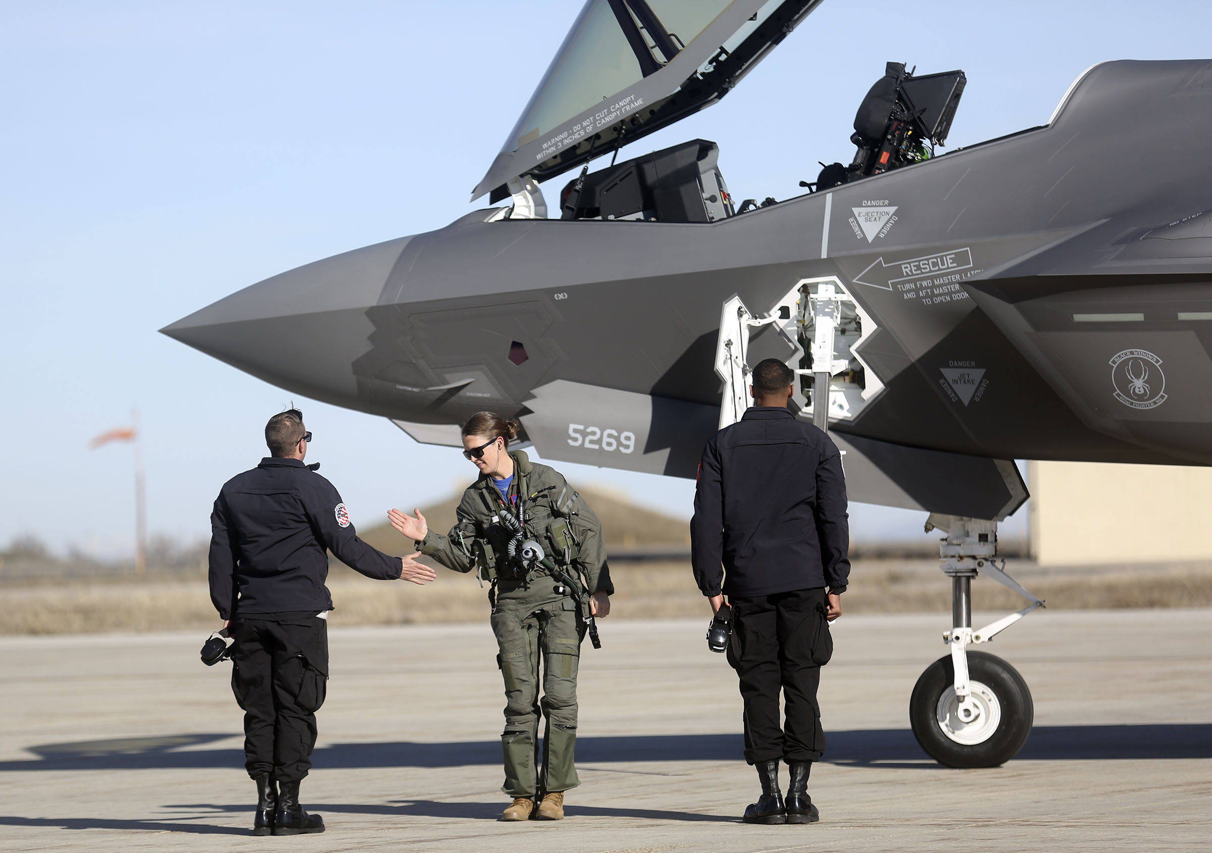 Air Force Capt. Kristin “BEO” Wolfe high-fives Senior Airman Matthew Spear, left, and Senior Airman Mathieu Cyrus, right, at Hill Air Force Base on Thursday, March 5, 2020, after finishing a flight in an F-35A Lightning II. (Kristin Murphy, KSL)