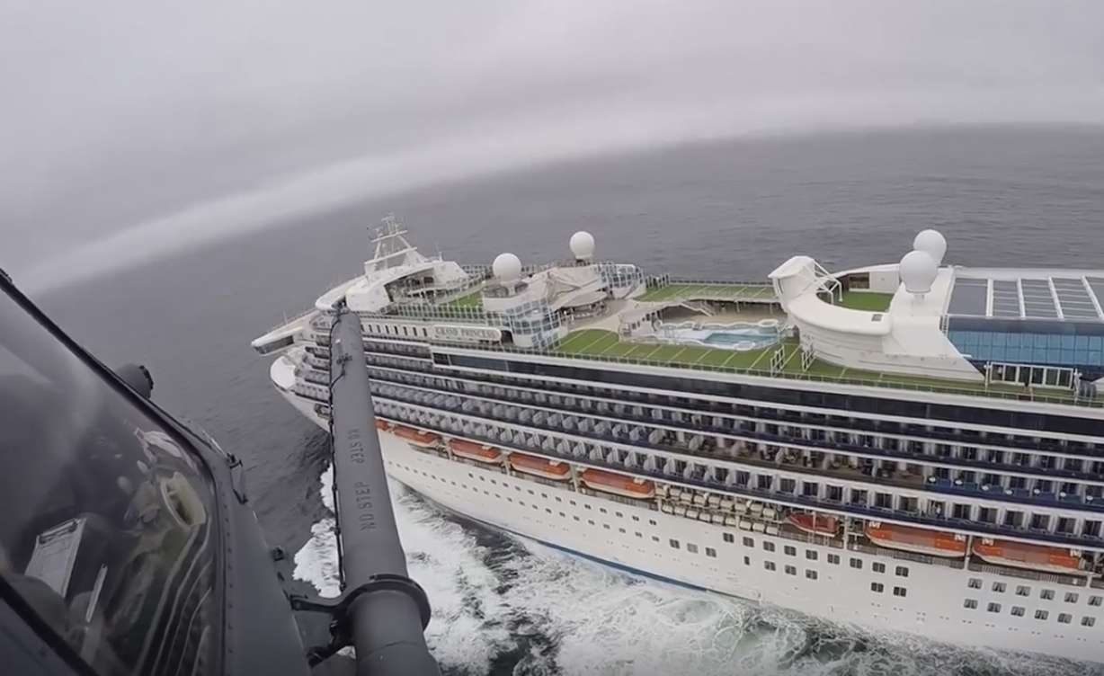 In this image from video, provided by the California National Guard, a helicopter carrying airmen with the 129th Rescue Wing flies over the Grand Princess cruise ship off the coast of California Thursday, March 5, 2020. (California National Guard via AP)