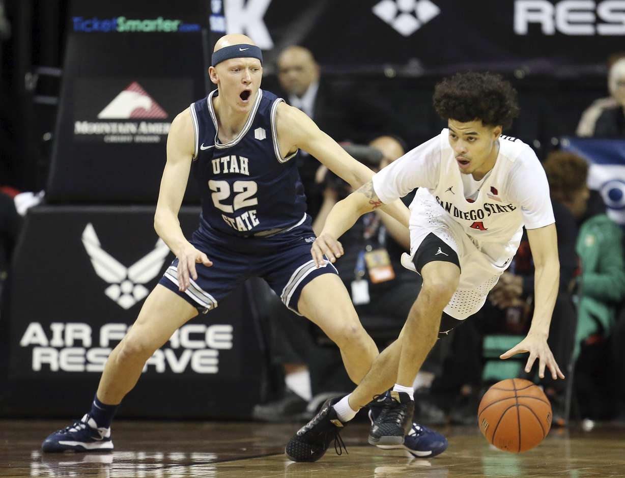 San Diego State's Trey Pulliam (4) drives as Utah State's Brock Miller (22) defends during the first half of an NCAA college basketball game for the Mountain West Conference men's tournament championship Saturday, March 7, 2020, in Las Vegas. (Photo: Isaac Brekken, AP)