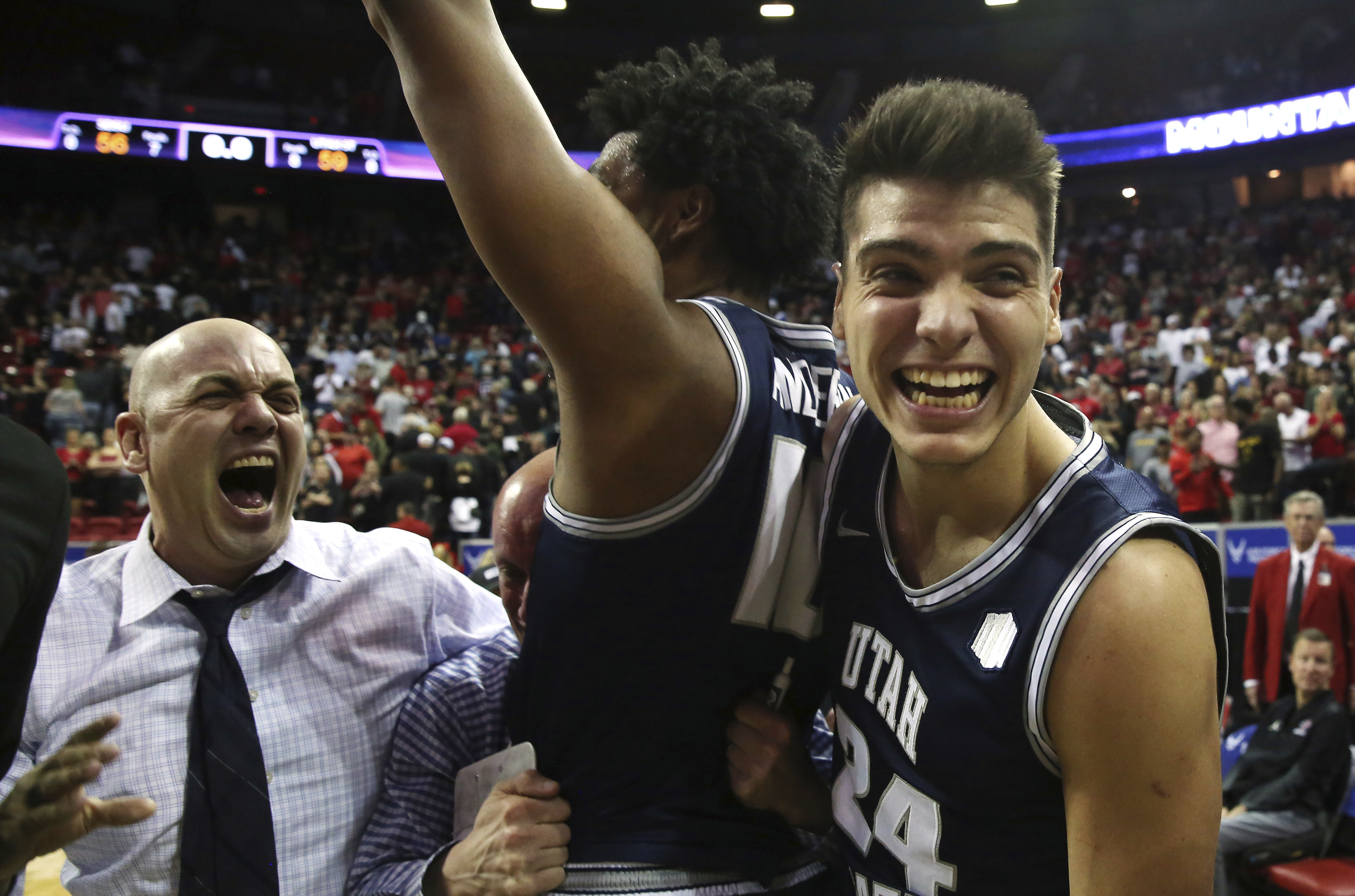 Utah State head coach Craig Smith, left, with players Alphonso Anderson, center, and Diogo Brito (24) celebrate following an NCAA college basketball game against San Diego State for the Mountain West Conference men's tournament championship Saturday, March 7, 2020, in Las Vegas.