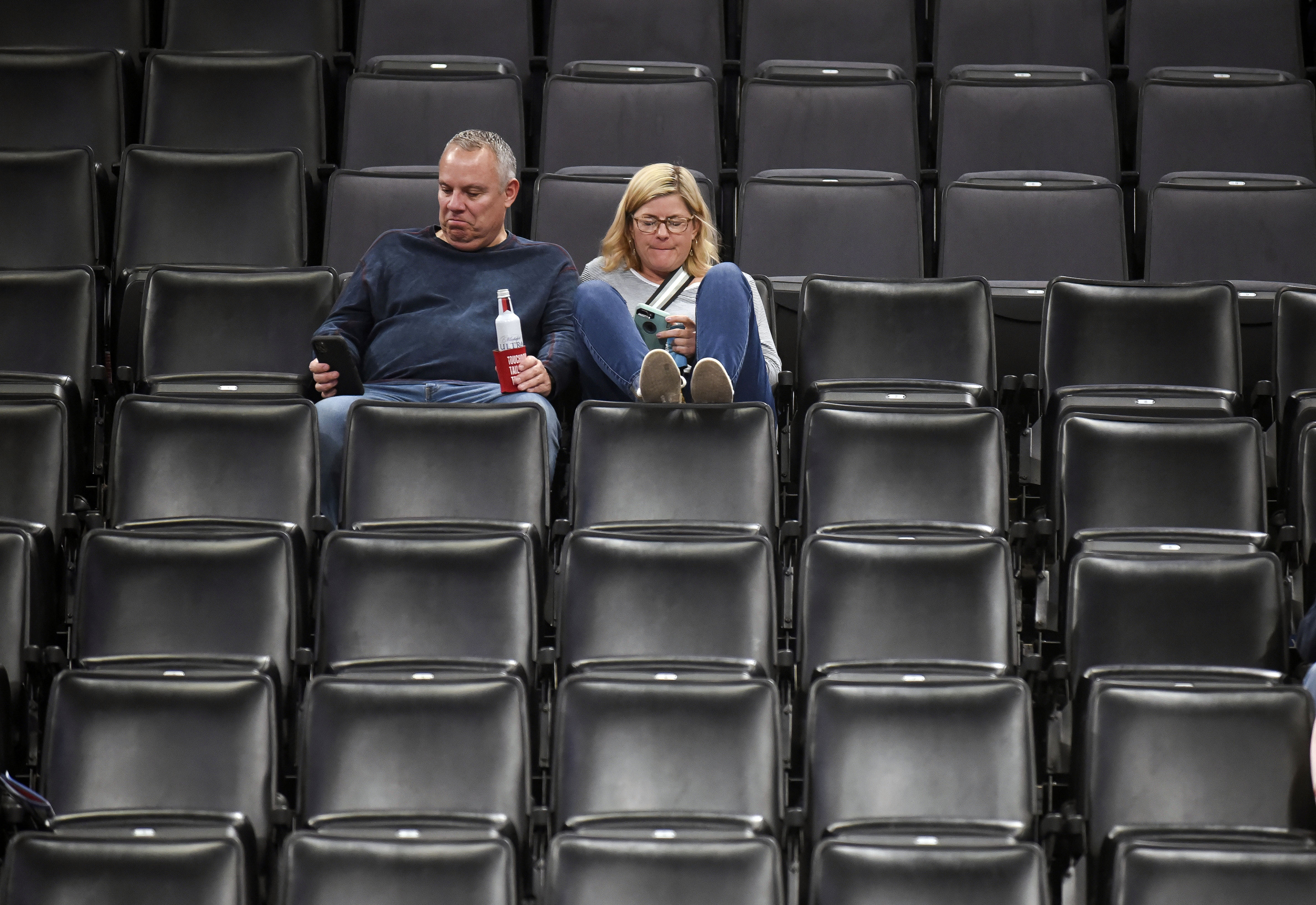 Basketball fans sit in an empty section after it is announced that an NBA basketball game between Oklahoma City Thunder and Utah Jazz in Oklahoma City has been postponed, Wednesday, March 11, 2020.