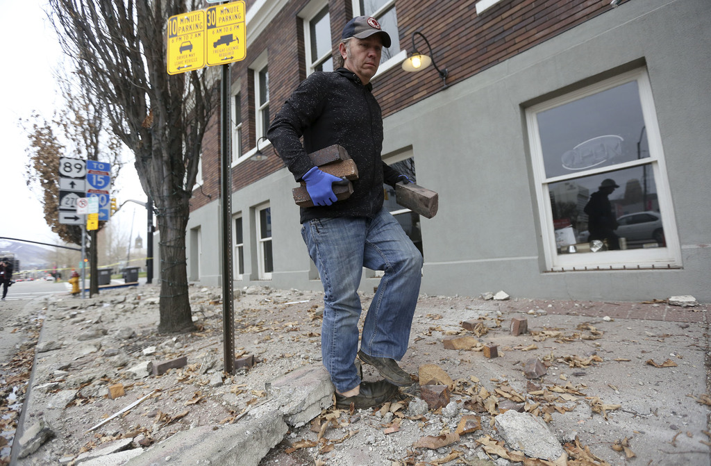 Fred Moesinger, owner of BTG Wine Bar and Caffe Molise in Salt Lake City, picks up bricks among debris that fell from his building after a 5.7 magnitude earthquake centered in Magna hit early on Wednesday, March 18, 2020. (Photo: Kristin Murphy, KSL)