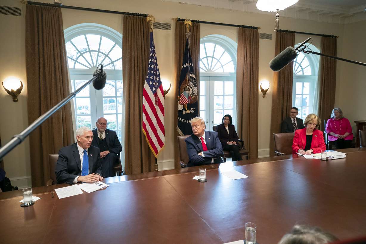 Vice President Mike Pence, left, speaks as President Donald Trump listens, about the coronavirus in the Cabinet Room of the White House during a meeting with representatives of American nurses, Wednesday, March 18, 2020, in Washington. (AP Photo/Alex Brandon)