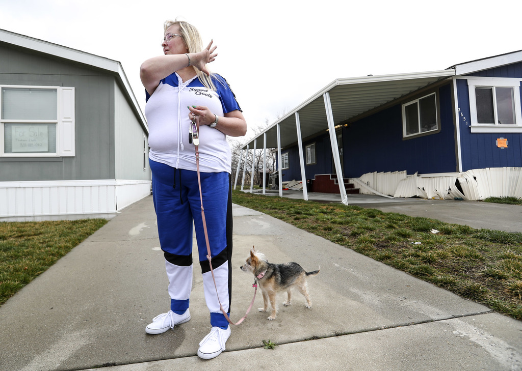 Carolyn Moser and her dog Chloe outside her trailer home, pictured at left, in Magna on Thursday, March 19, 2020, following Wednesday's 5.7 earthquake. Moser, who left her home following the earthquake after smelling gas, returned to her home Thursday to check on everything. (Photo: Steve Griffin, KSL)