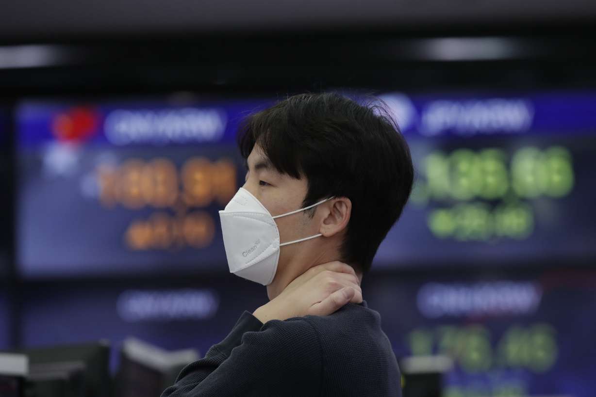 A currency trader wearing a face mask stands near the screens showing the foreign exchange rates at the foreign exchange dealing room in Seoul, South Korea, Friday, March 20, 2020. (Photo: AP Photo/Lee Jin-man)