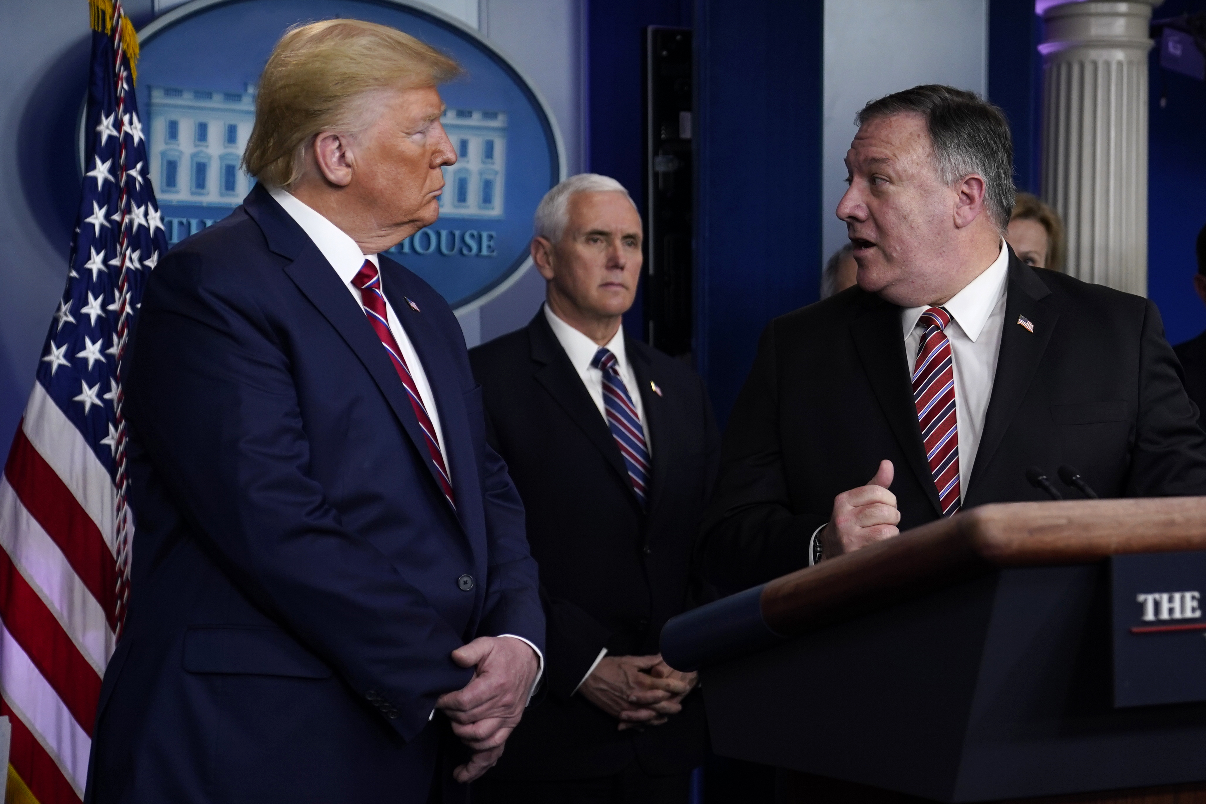 President Donald Trump, left, listens as Secretary of State Mike Pompeo speaks during a coronavirus task force briefing at the White House, Friday, March 20, 2020, in Washington. (AP Photo/Evan Vucci)