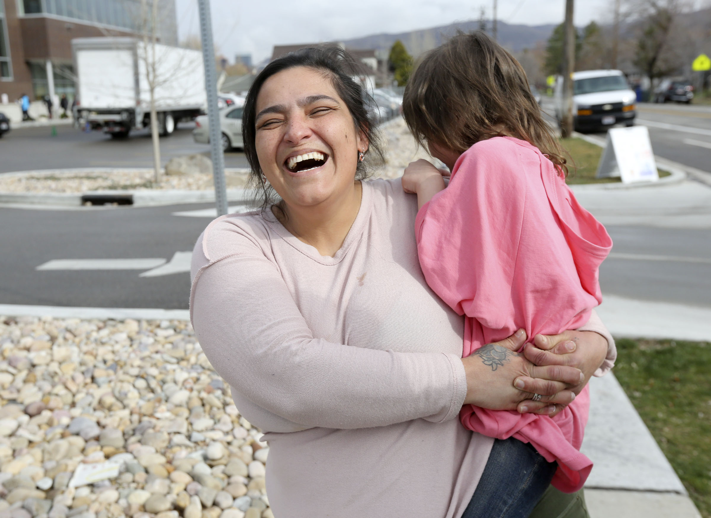 Frankie Runnells laughs at her daughter Mia Runnells after picking up emergency food and hygiene kits outside of the Liberty Community Learning Center in Salt Lake City on Friday, March 20, 2020. Runnells and her family recently became homeless. The Salt Lake Education Foundation and community partners are providing the kits to Salt Lake City school district families. (Kristin Murphy, KSL)