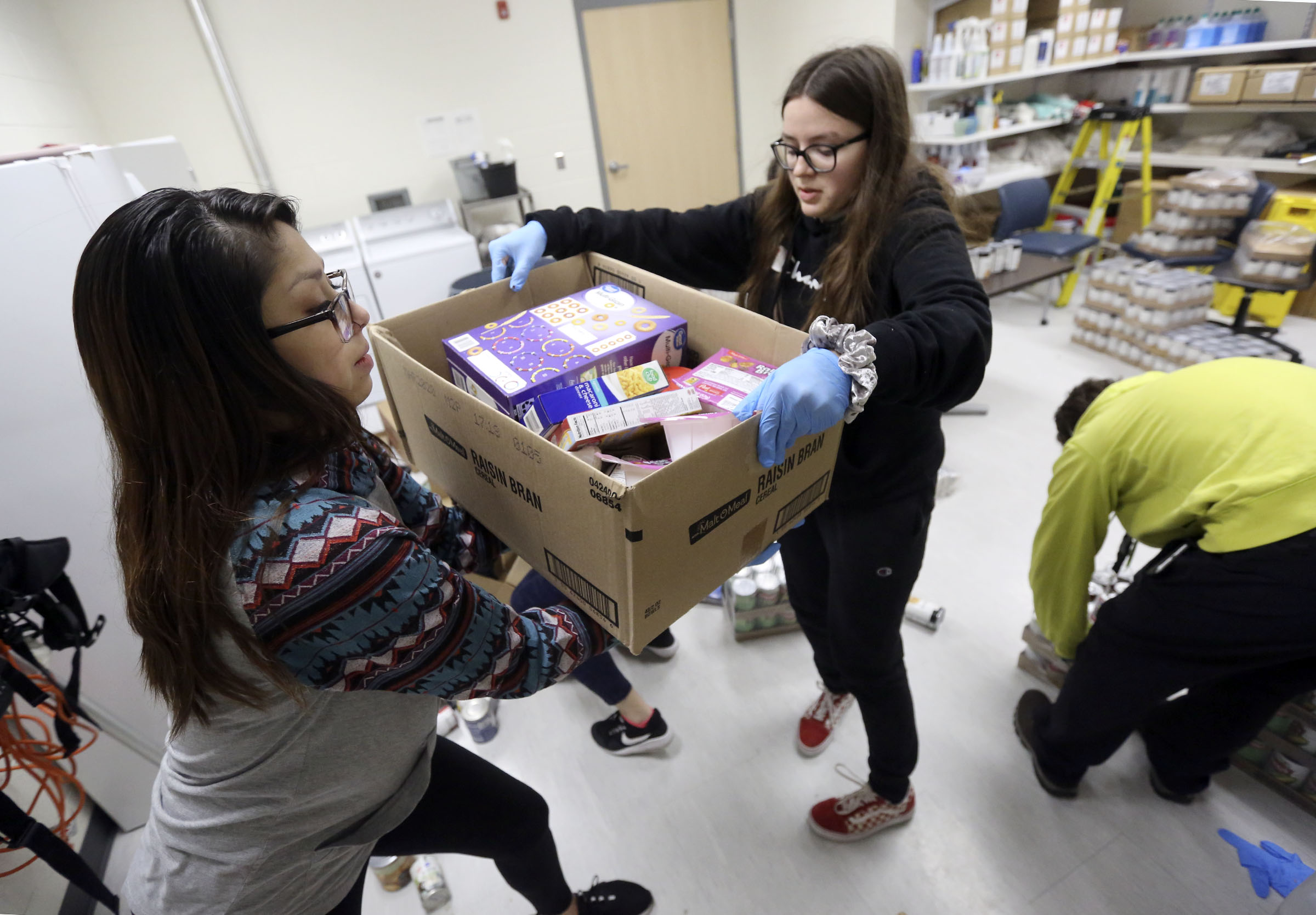 Maria Morales and Verena Eyre prepare boxes of emergency food and hygiene kits to hand out at the Liberty Community Learning Center in Salt Lake City on Friday, March 20, 2020. (Kristin Murphy, KSL)