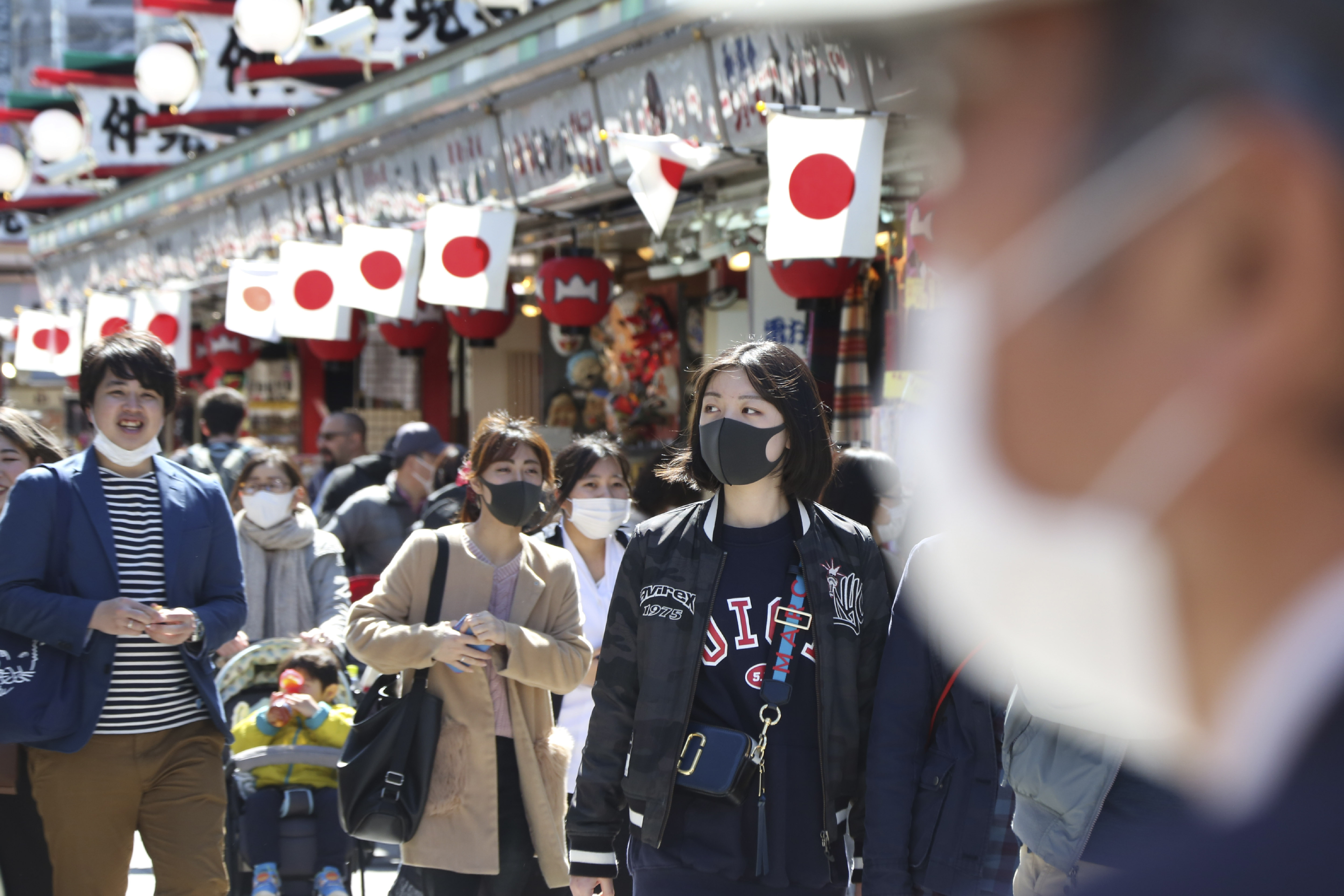 Visitors wearing face masks walk through Nakamise alley at Asakusa in Tokyo, Friday, March 20, 2020. For most people, the new coronavirus causes only mild or moderate symptoms. For some it can cause more severe illness. (Photo: Koji Sasahara, AP)