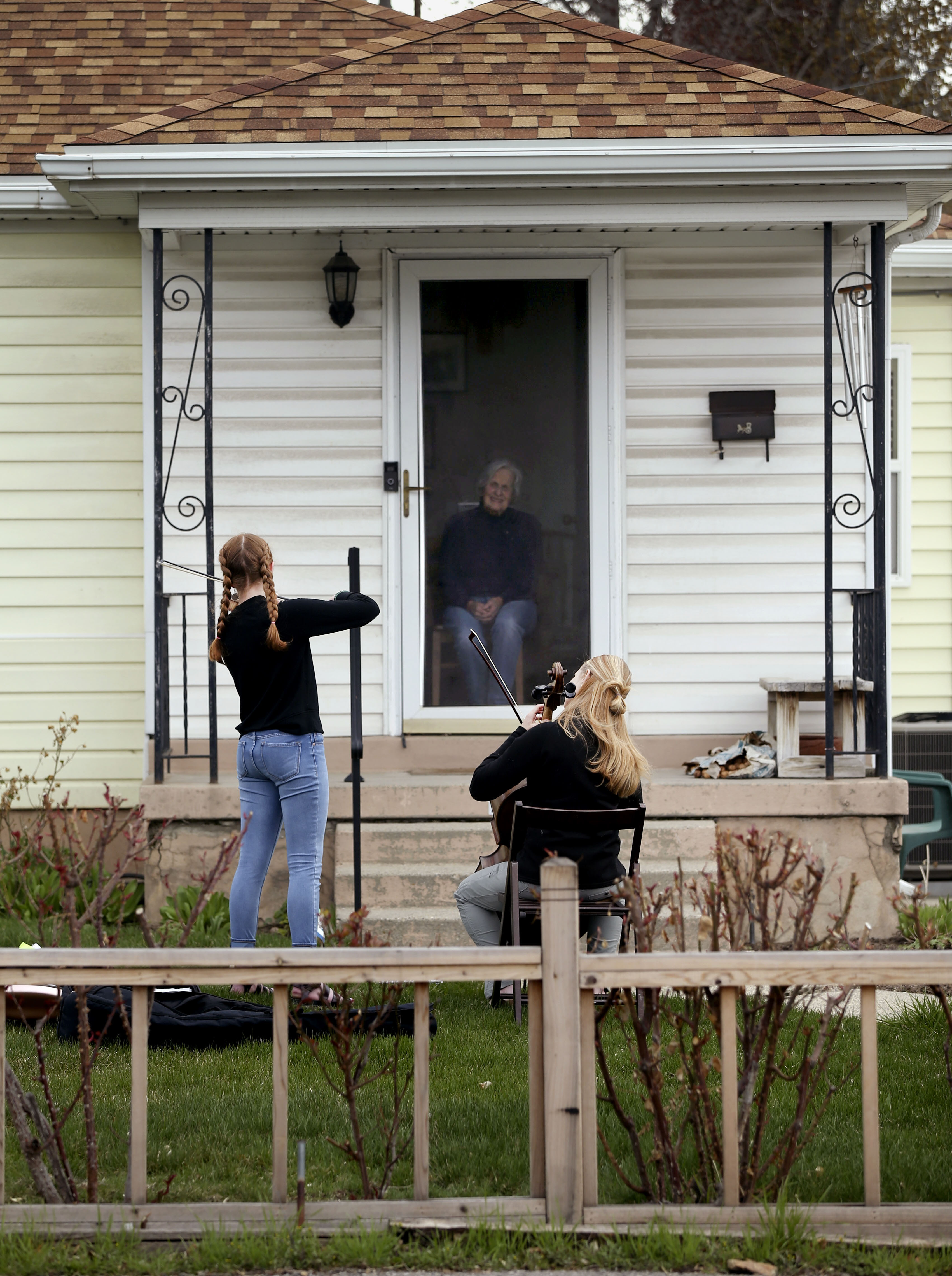 Vivian Stewart, 13, and her mother, Kelly McConkie Stewart, perform for Helen Gygi in Salt Lake City on Wednesday, April 1, 2020. The mother/daughter duo have been performing concerts to not only lift their neighbors’ spirits, but their own as well. (Photo: Spenser Heaps, KSL)