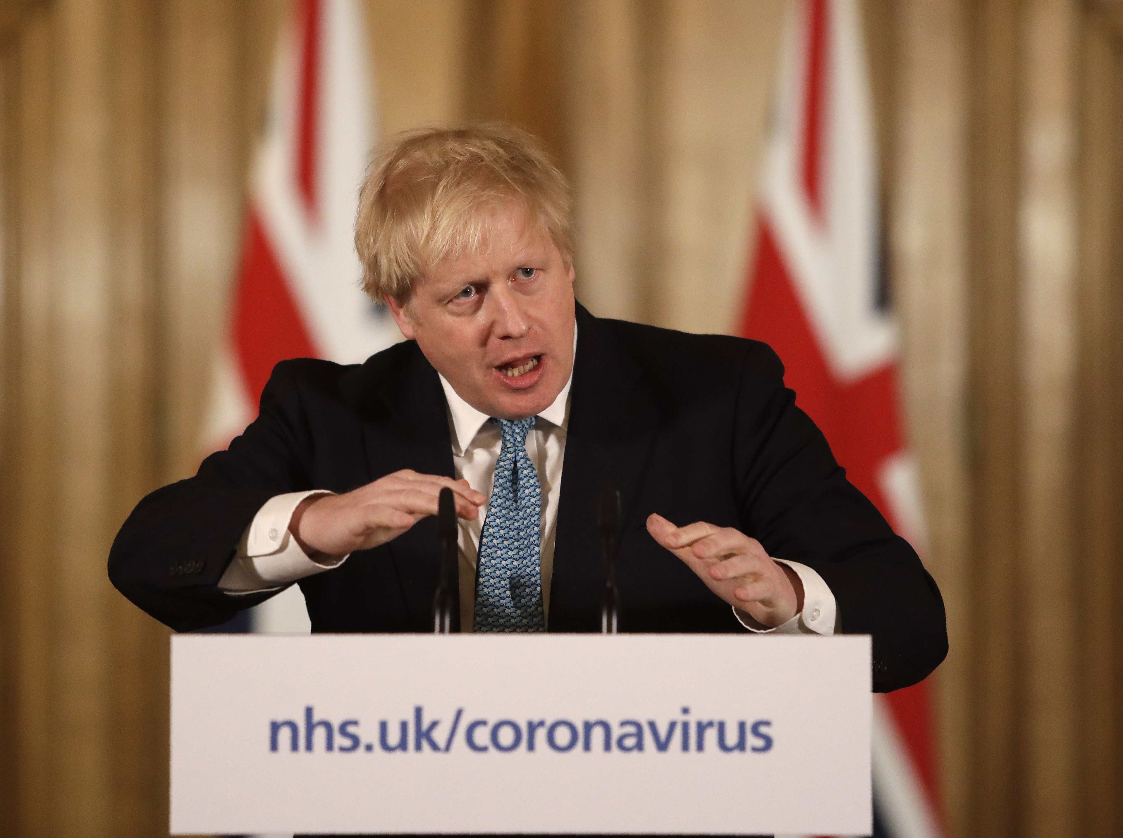 FILE - In this Tuesday, March 17, 2020 file photo British Prime Minister Boris Johnson gestures as he gives a press conference about the ongoing situation with the COVID-19 coronavirus outbreak inside 10 Downing Street in London. British Prime Minister Boris Johnson has been admitted to a hospital with the coronavirus. Johnson's office says he is being admitted for tests because he still has symptoms 10 days after testing positive for the virus.