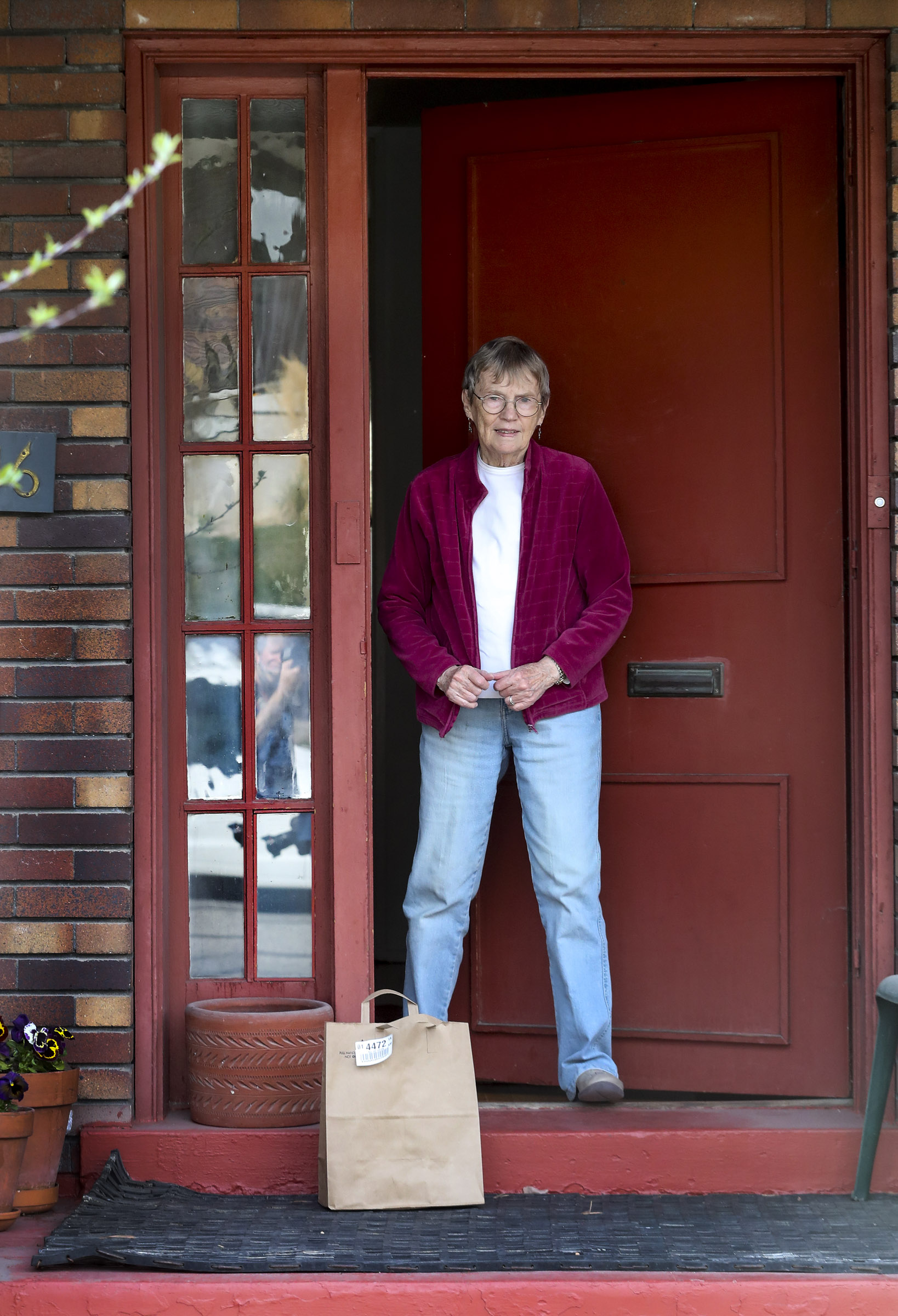 Klancy de Nevers opens her front door to collect groceries that were delivered to her home near the University of Utah by U. student Ben Haggard in Salt Lake City on Wednesday, April 8, 2020. Haggard is part of “Leave it to Us” a delivery service that is helping senior citizens by doing errands for them so they don’t need to leave their home during the COVID-19 pandemic. (Photo: Steve Griffin, KSL)
