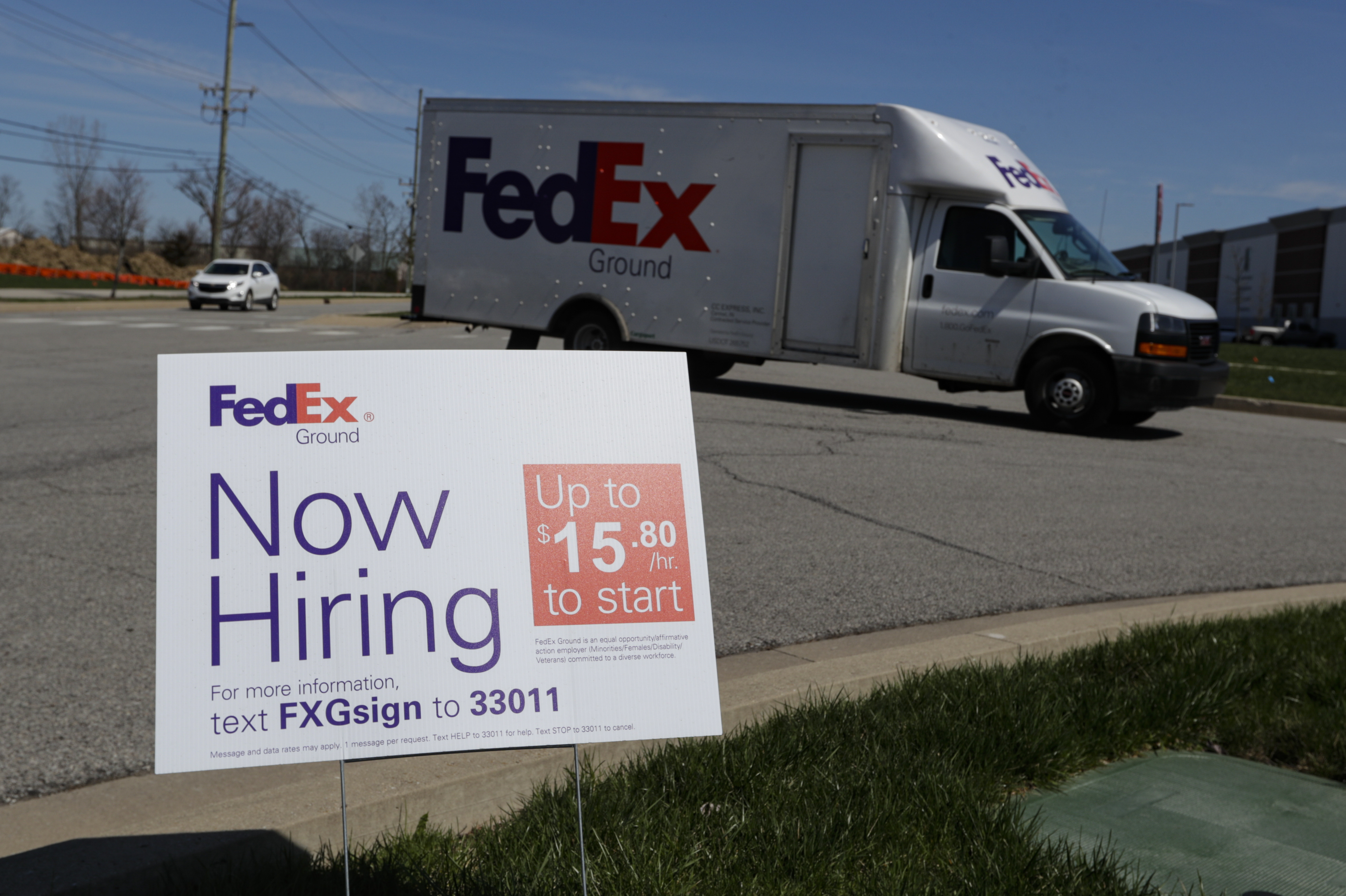 A sign advertising for jobs sits along the roadside outside a FedEx location in Zionsville, Ind., Thursday, April 2, 2020. (AP Photo/Michael Conroy)