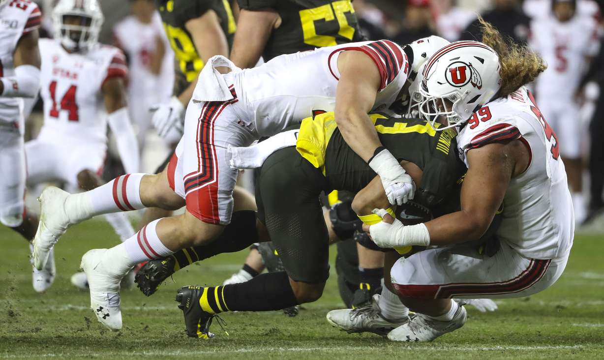 Utah Utes defensive end Mika Tafua (42) and Utah Utes defensive tackle Leki Fotu (99) tackle Oregon Ducks wide receiver Johnny Johnson III (3) during the Pac-12 Championship game at Levi’s Stadium in Santa Clara, Calif., on Friday, Dec. 6, 2019.