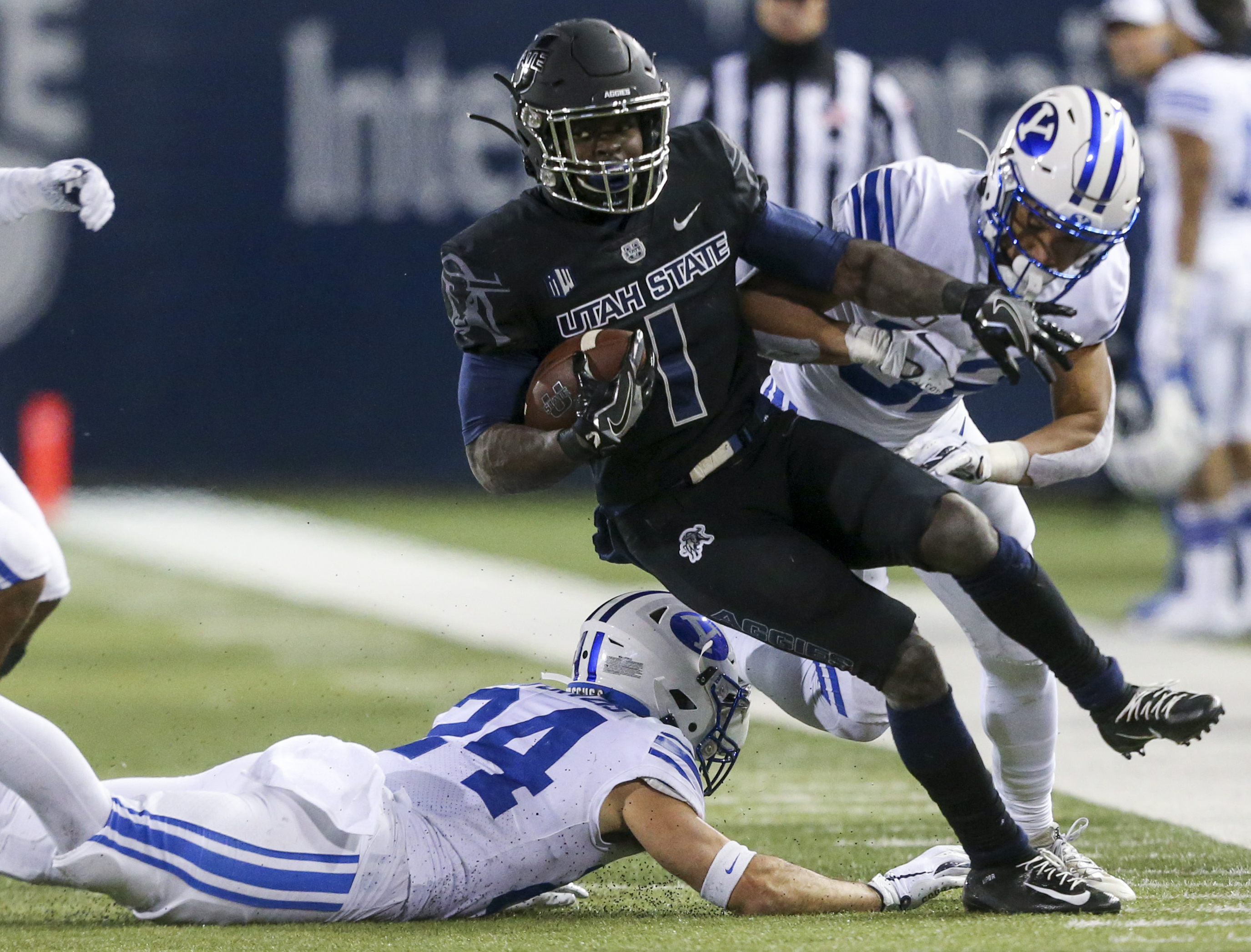 Utah State Aggies running back Gerold Bright (1) keeps the run alive, avoiding Brigham Young Cougars defensive back Chris Wilcox (32) and breaking defensive back Austin Kafentzis' (24) tackle during the second half of an NCAA football game at Maverik Stadium in Logan on Saturday, Nov. 2, 2019. The Brigham Young Cougars took back the wagon wheel in a dominant 42-14 victory over the Utah State Aggies.